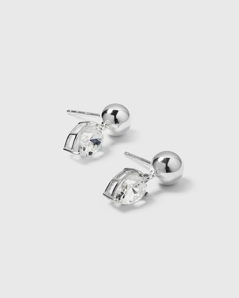 A product shot of the Katie Earrings in silver, featuring a ball stud design with a dangling, drop-shaped cubic zirconia.