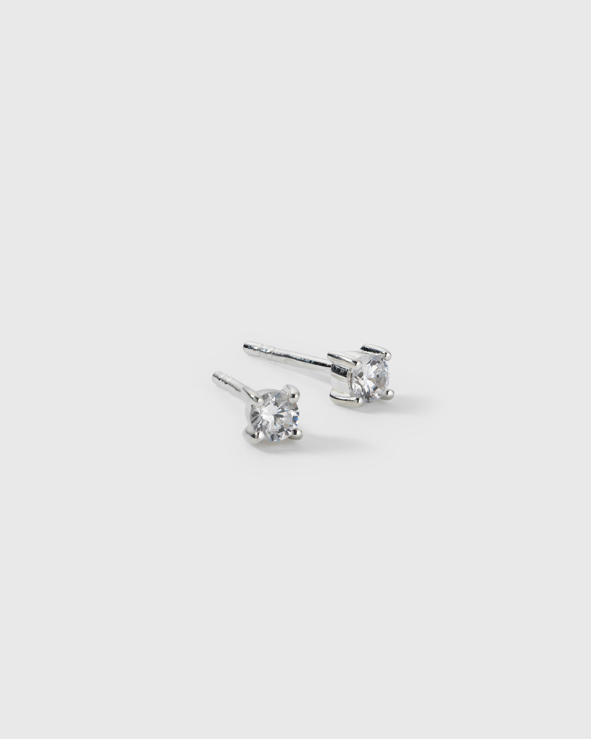 A product shot of the Celestia Small Studs in silver, a pair of classic studs each featuring a single cubic zirconia stone set with four prongs.