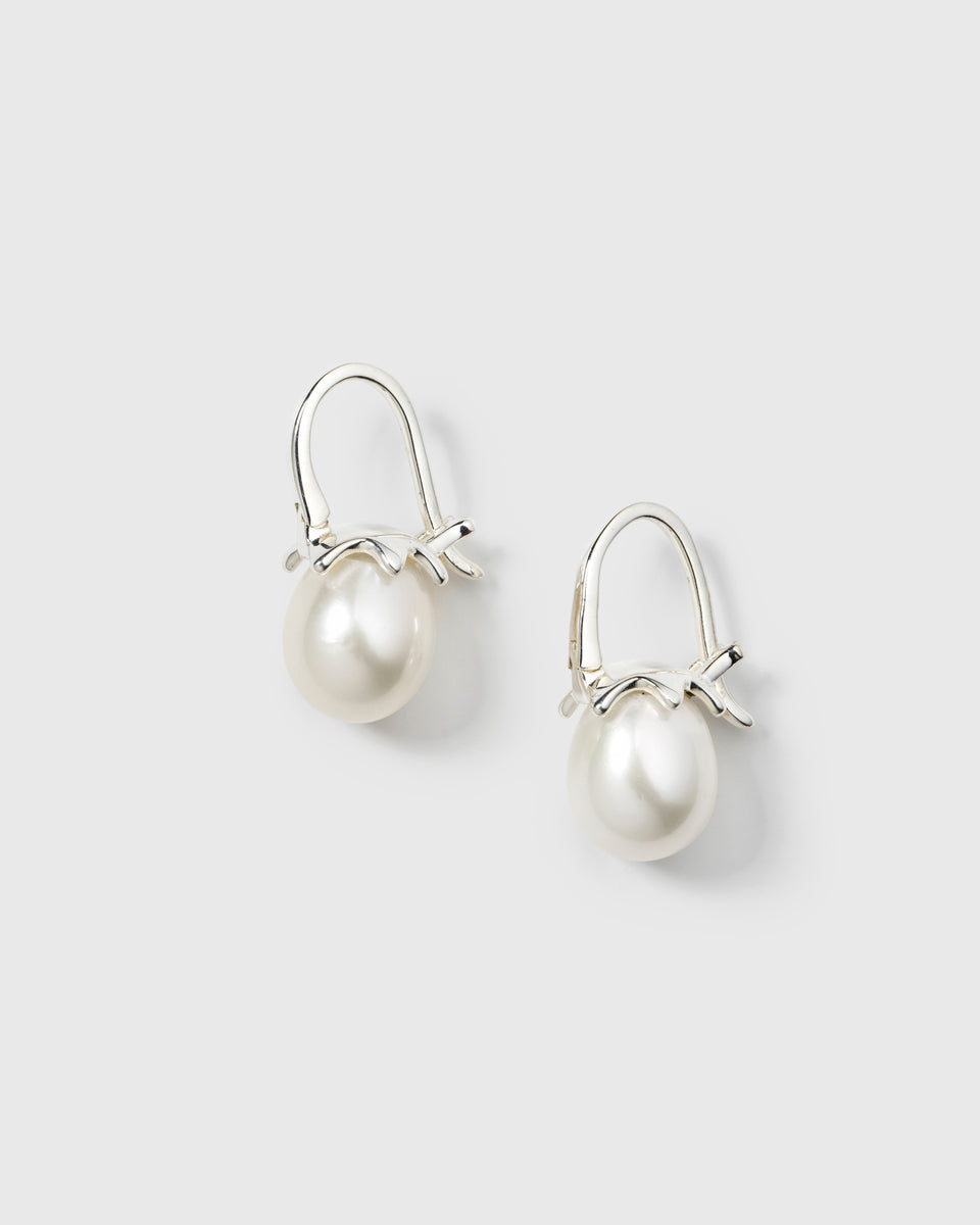 Hoop earrings with dangling white freshwater pearls and silver bow detail.