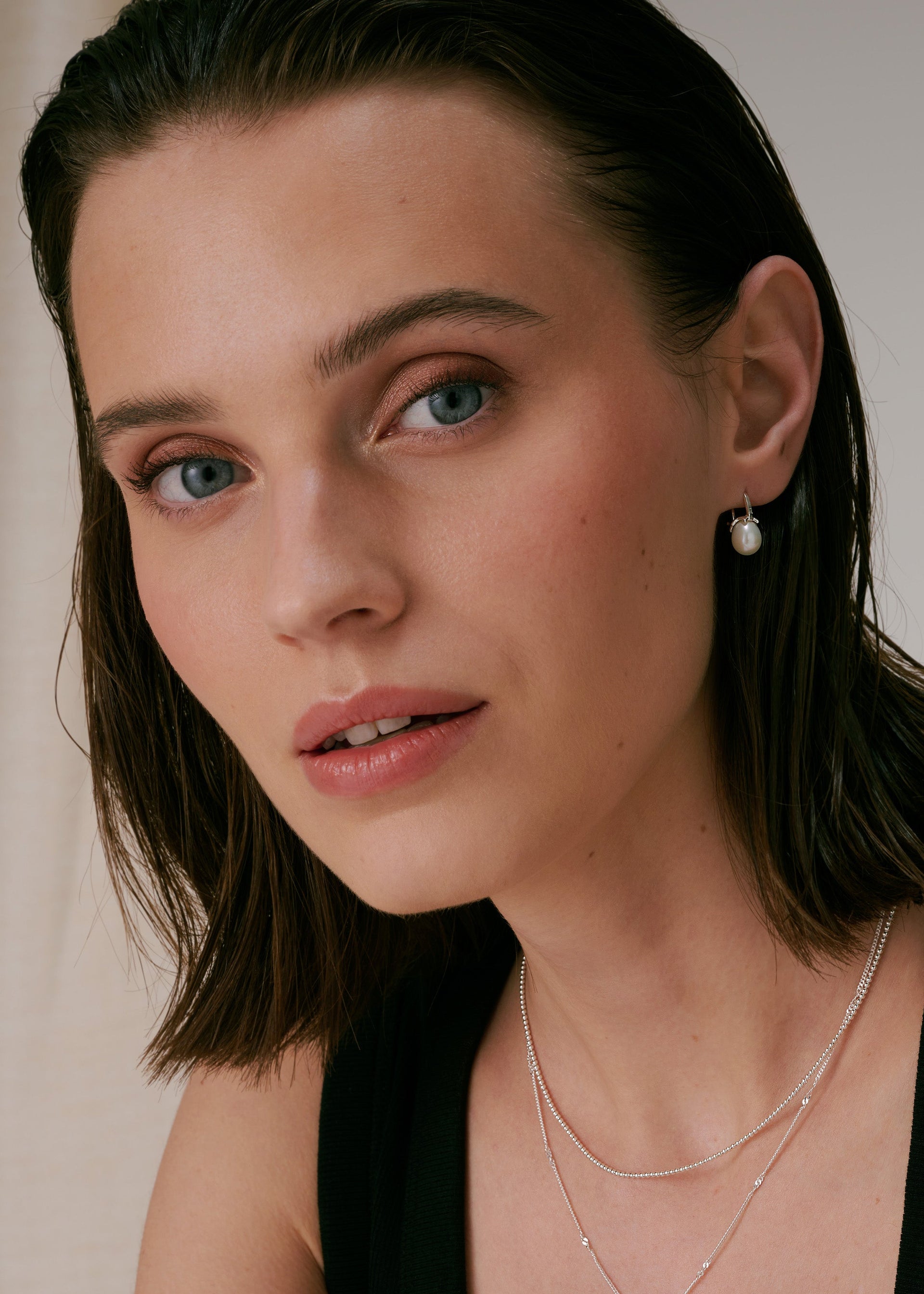 Silver pearl earrings with delicate freshwater pearl, paired with two layered silver necklaces.