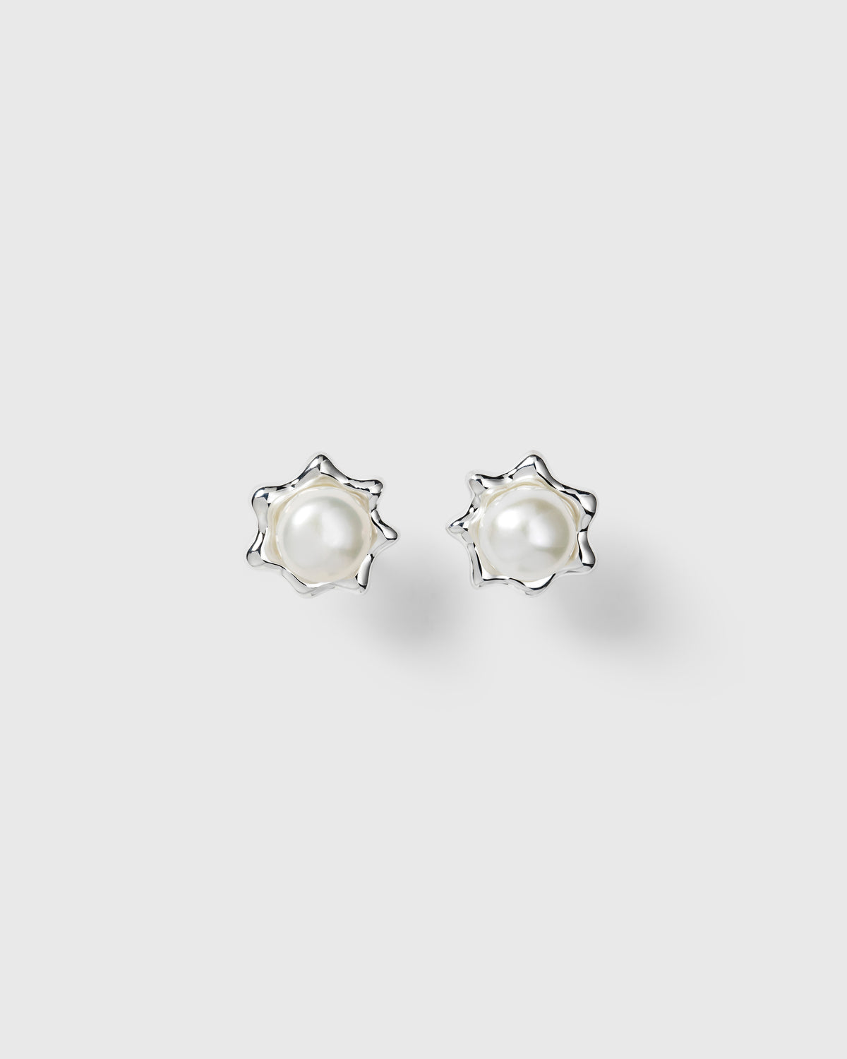 Silver earrings with freshwater pearls in organic star-shaped design.