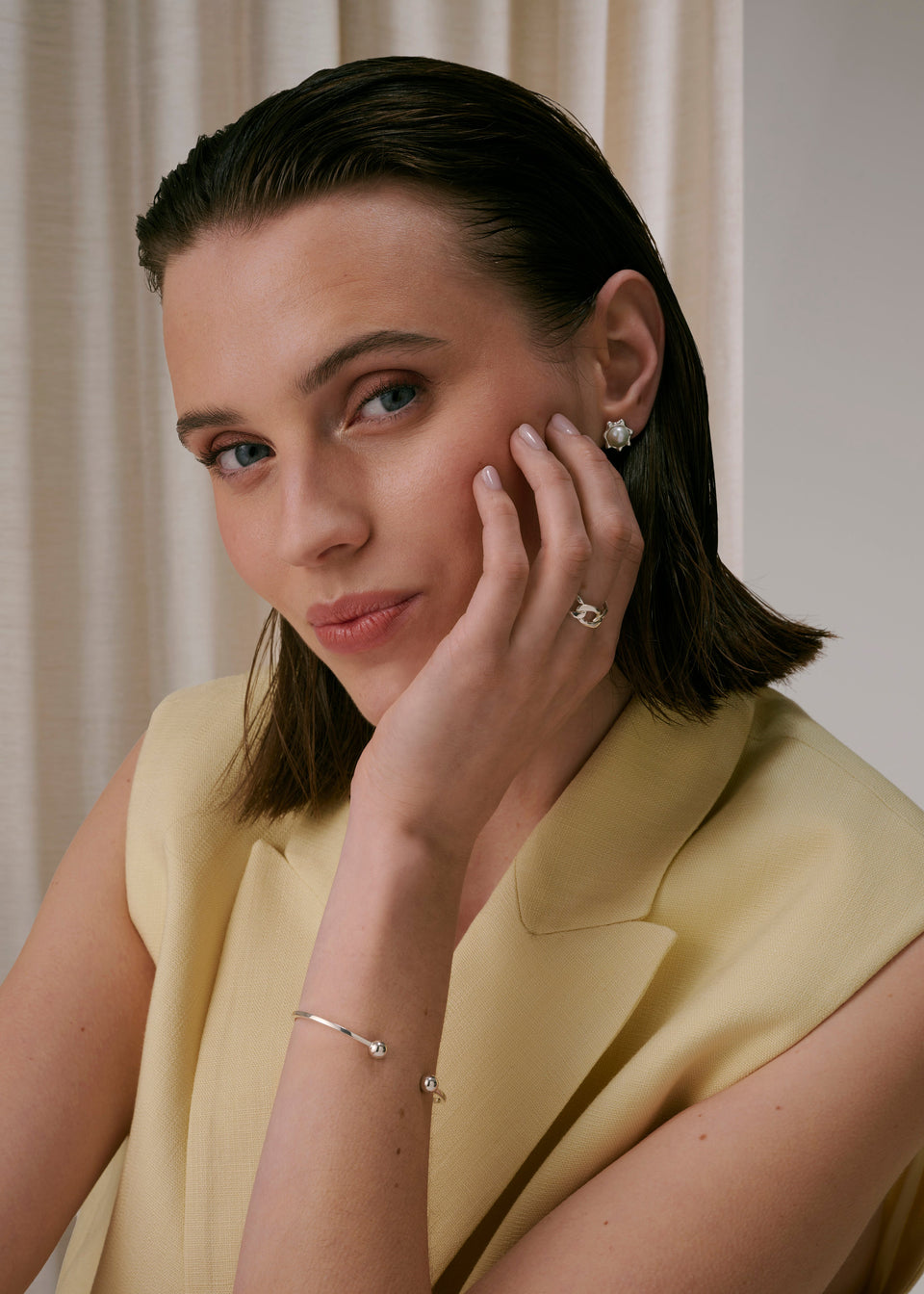 Silver pearl stud earrings, silver chain-design ring, and silver open bangle bracelet.