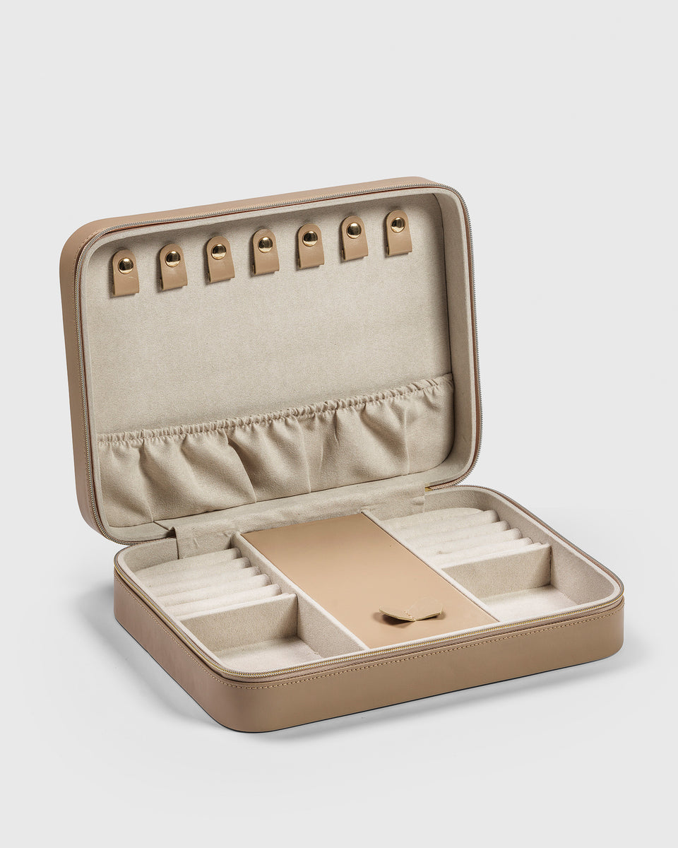 A product shot of the Jewelry Case Large in beige, shown open to reveal its soft interior with multiple compartments designed for organizing necklaces, rings, and other jewelry.