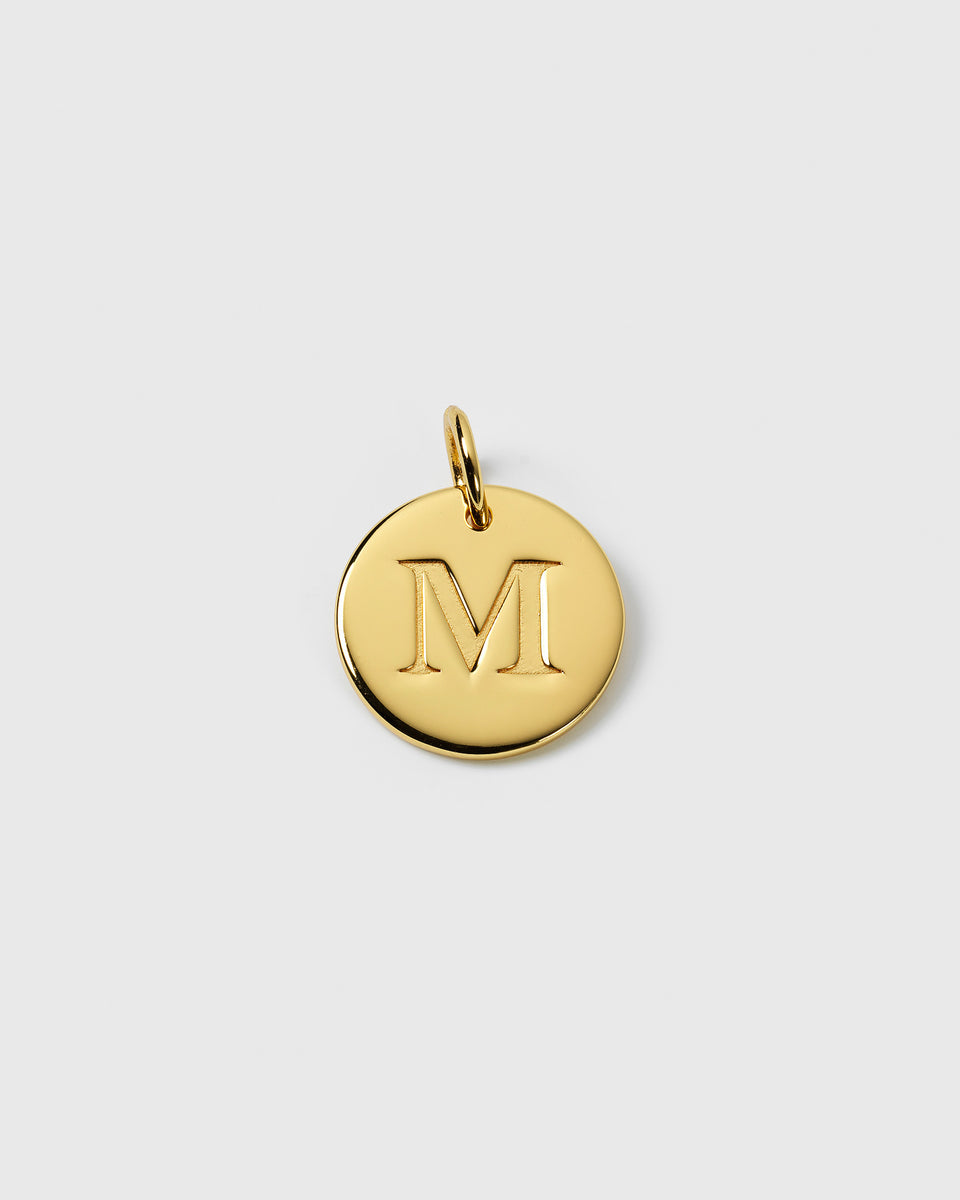 A product shot of the Beloved Big Letter Gold pendant, featuring a round charm with the letter 'M' engraved in the centre.