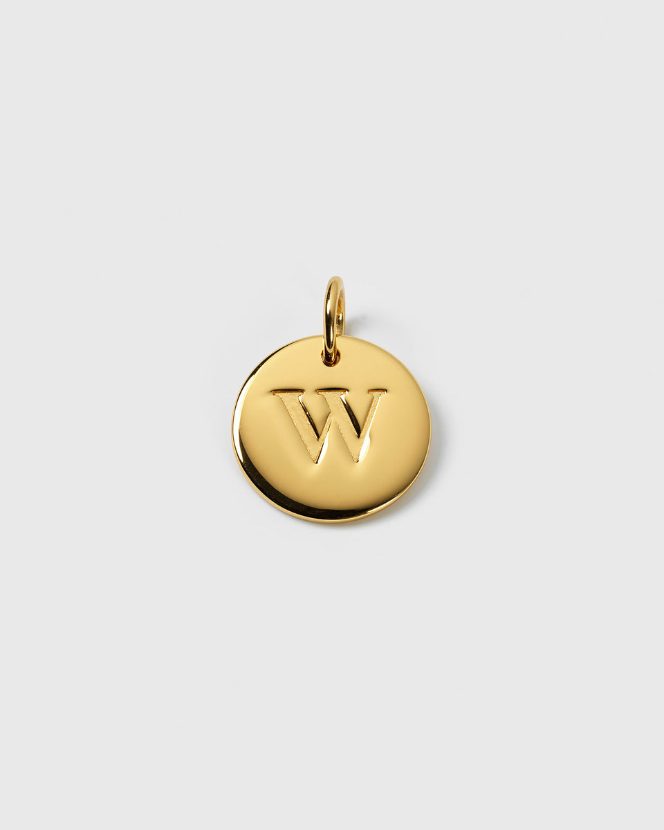 A product shot of the Beloved Big Letter pendant in gold, featuring the letter W engraved on its circular surface.