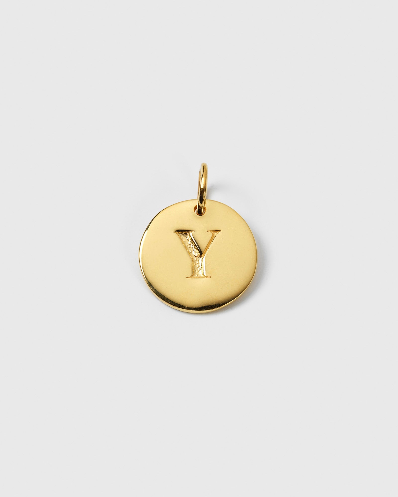 A product shot of the Beloved Big Letter 'Y' charm in gold, a round pendant with the initial engraved in the center.