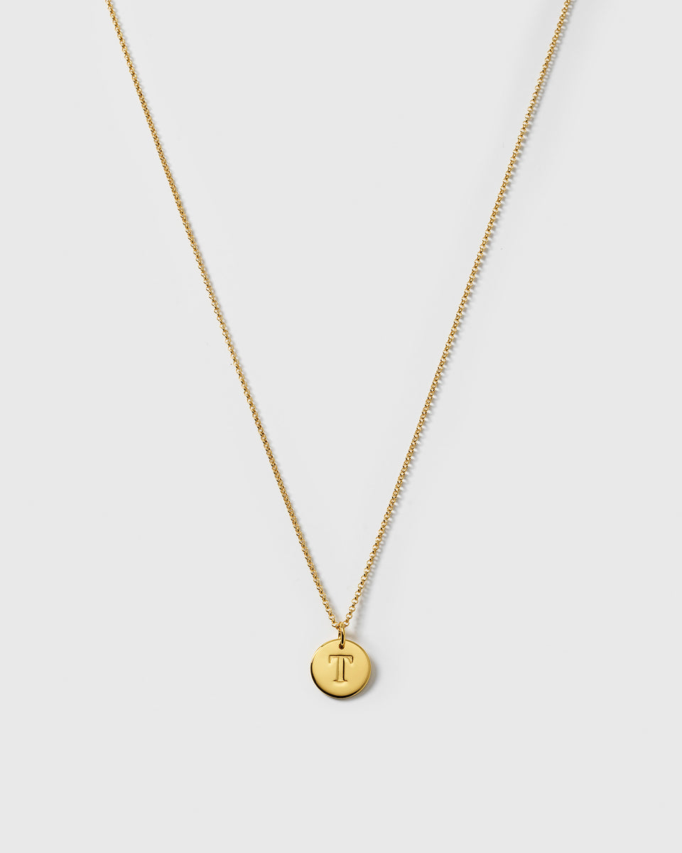 A product shot of the Beloved Medium Rolo Chain in gold, shown with a round gold pendant engraved with the letter 'T'.