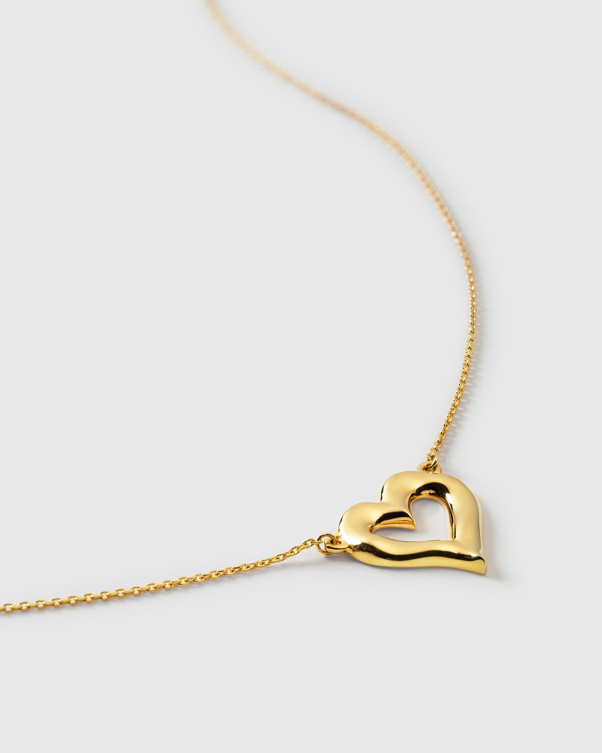A close-up of the Puff Heart Necklace in gold, showcasing its chunky, organic heart-shaped pendant and delicate chain.