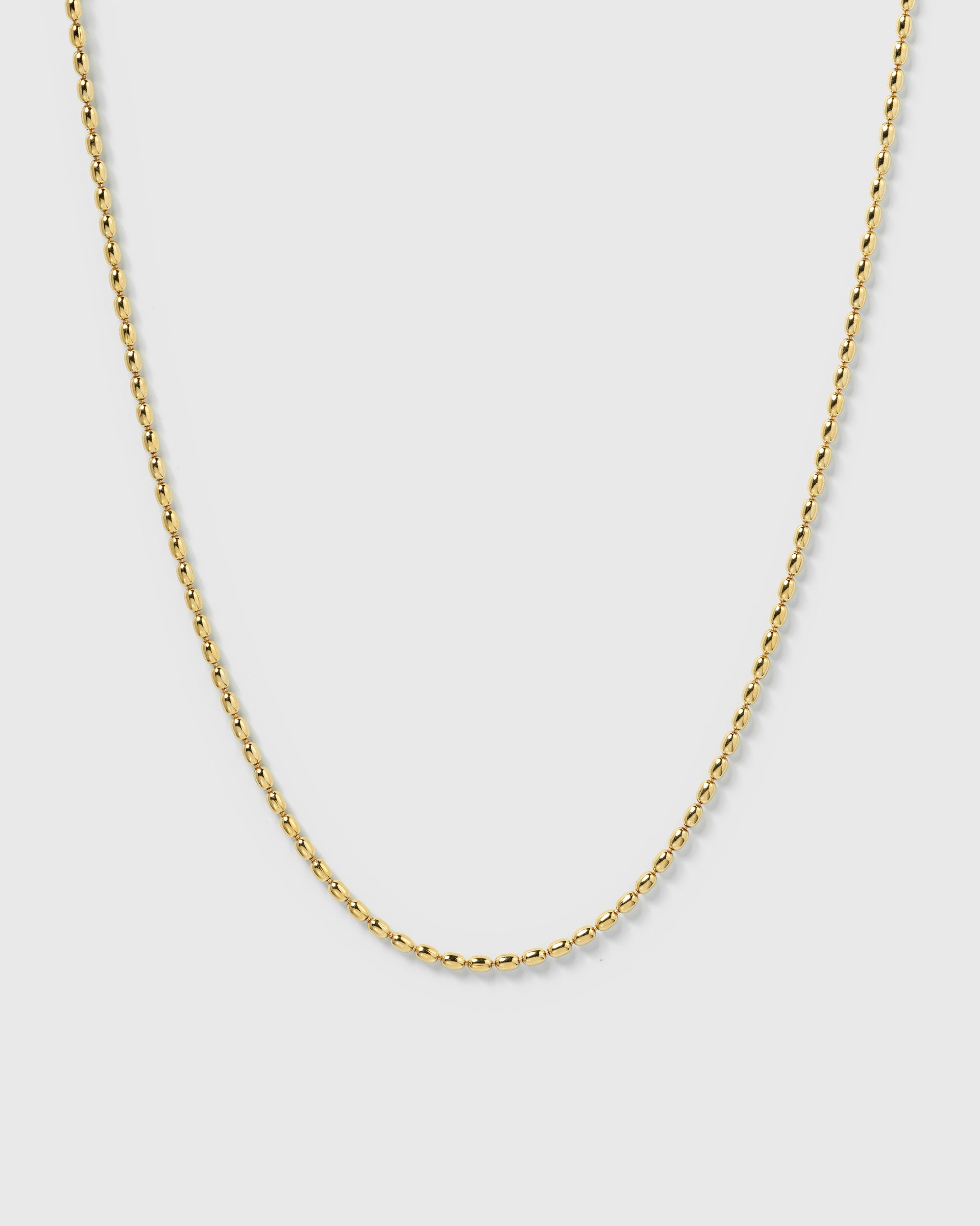 A product shot of the Lunetta Necklace in gold, highlighting its delicate chain composed of small, polished oval beads.