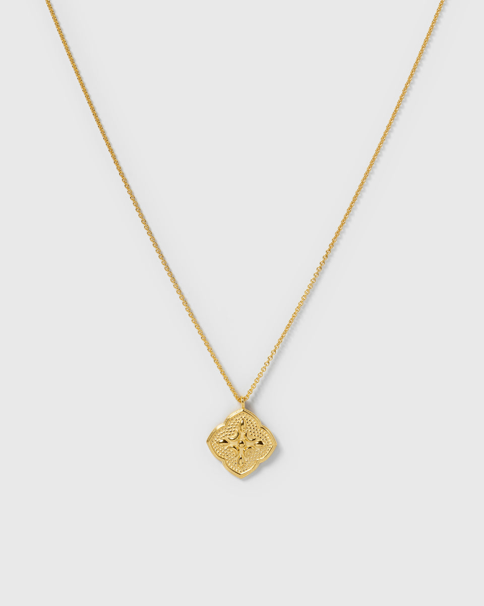 A product shot of the Luna Necklace in gold, featuring a delicate chain and an ornate, quatrefoil-shaped pendant with detailed engravings.