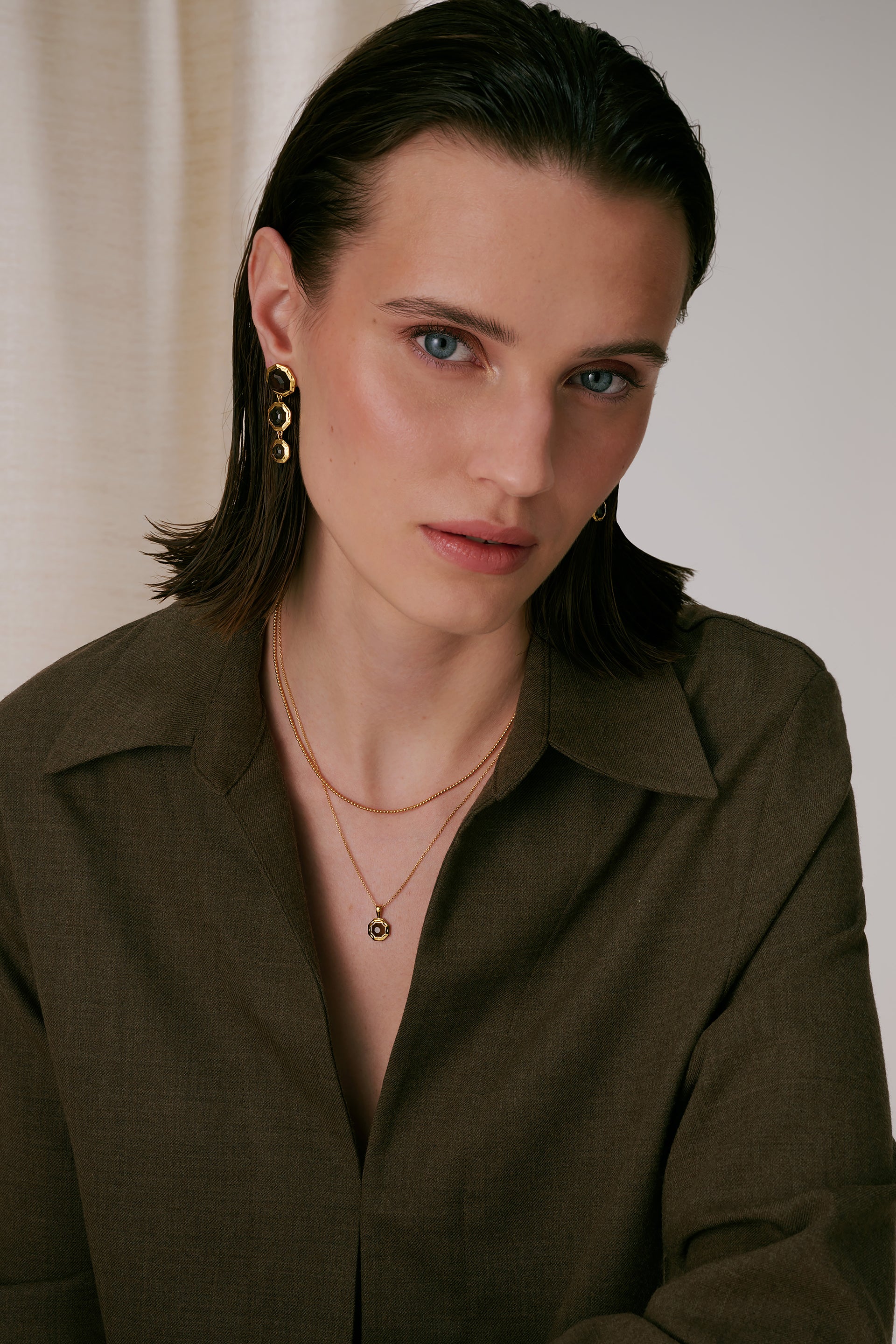 A necklace is adorned with an octagon-shaped pendant set with a faceted smokey quartz in a hammered setting.