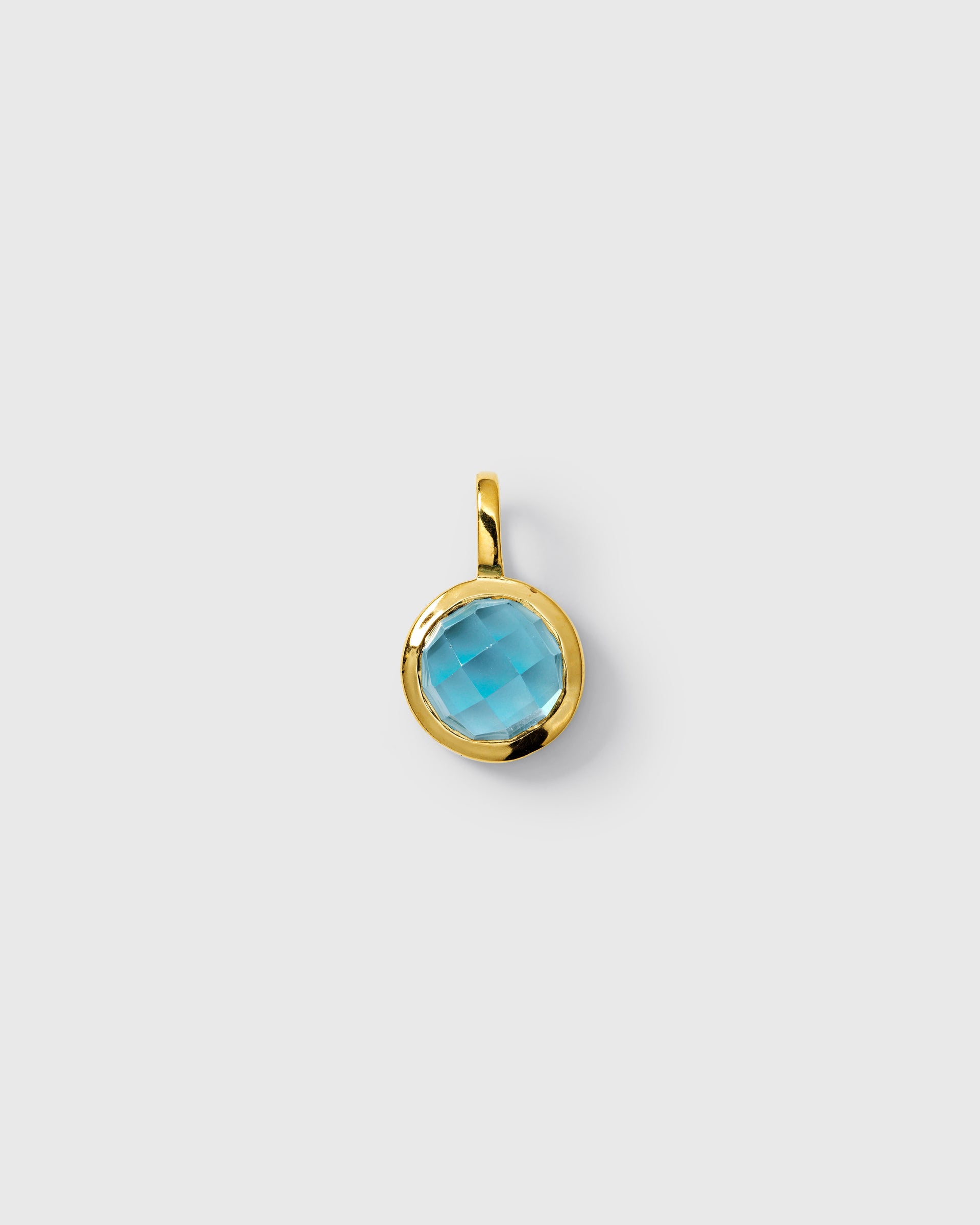 Gold pendant featuring a round faceted blue topaz, September birthstone.