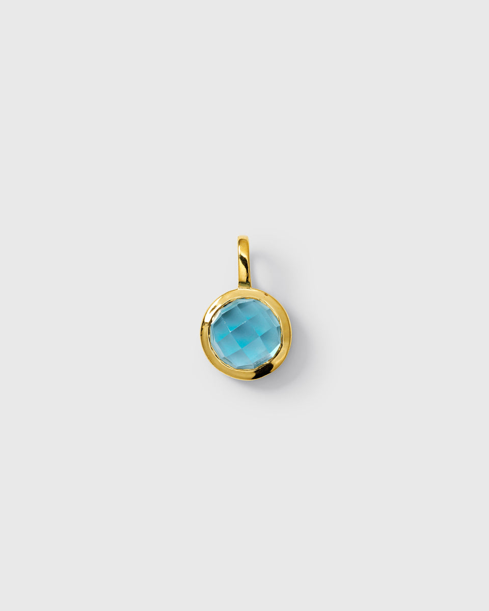 Gold pendant featuring a round faceted blue topaz, September birthstone.