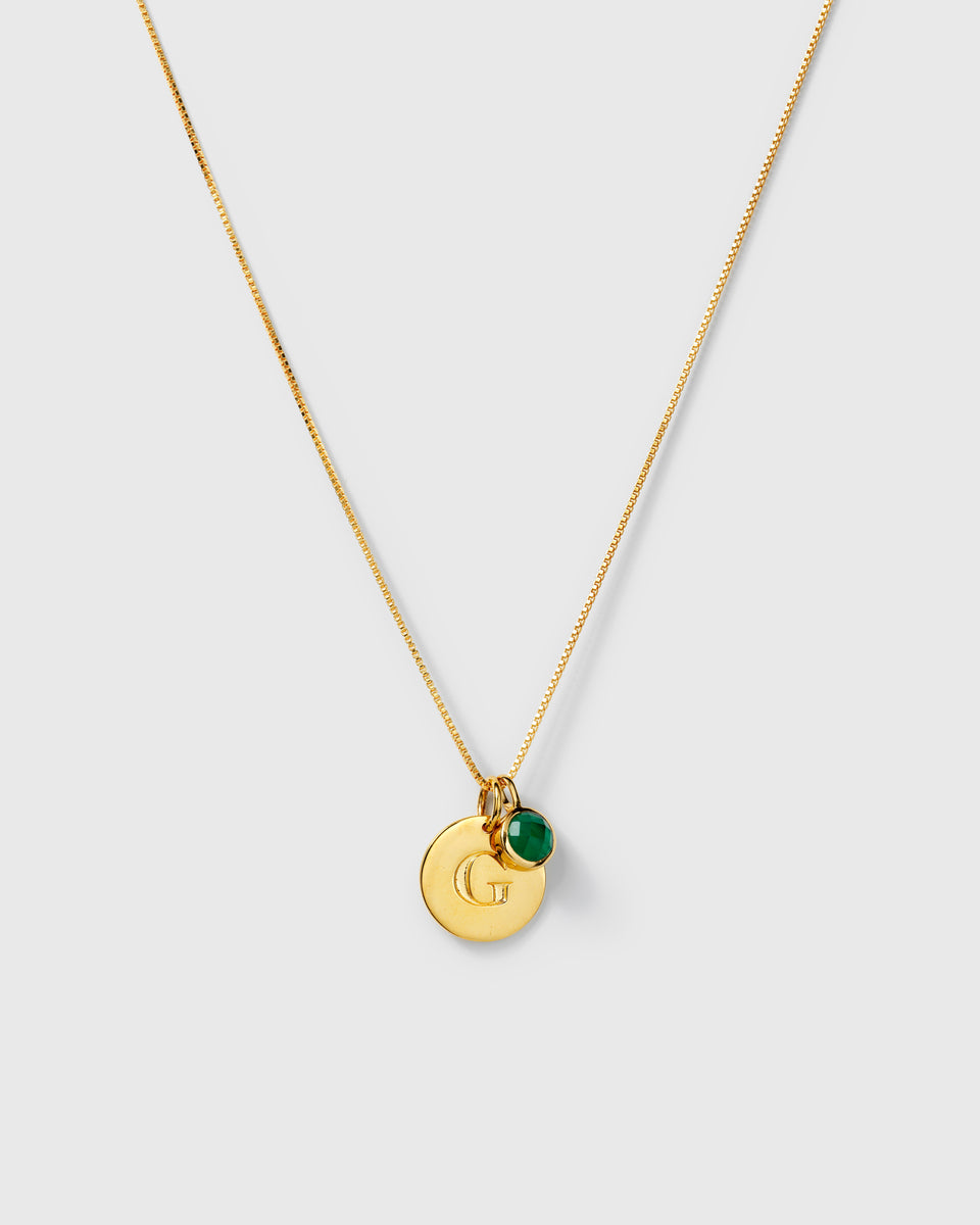 Gold necklace with two pendants: a May birthstone green onyx and a round letter charm.