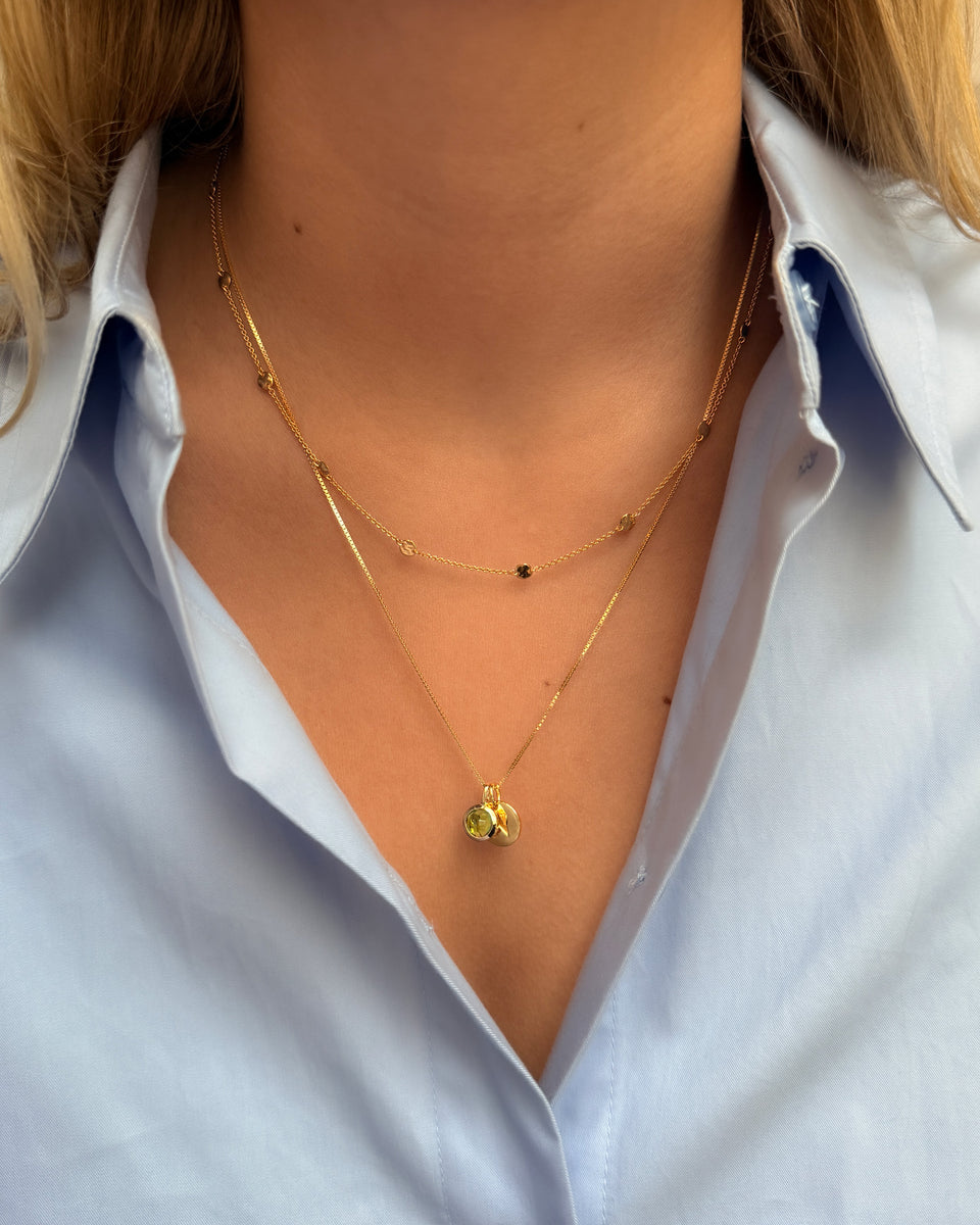 Gold necklace featuring August birthstone peridot, paired with a delicate chain.