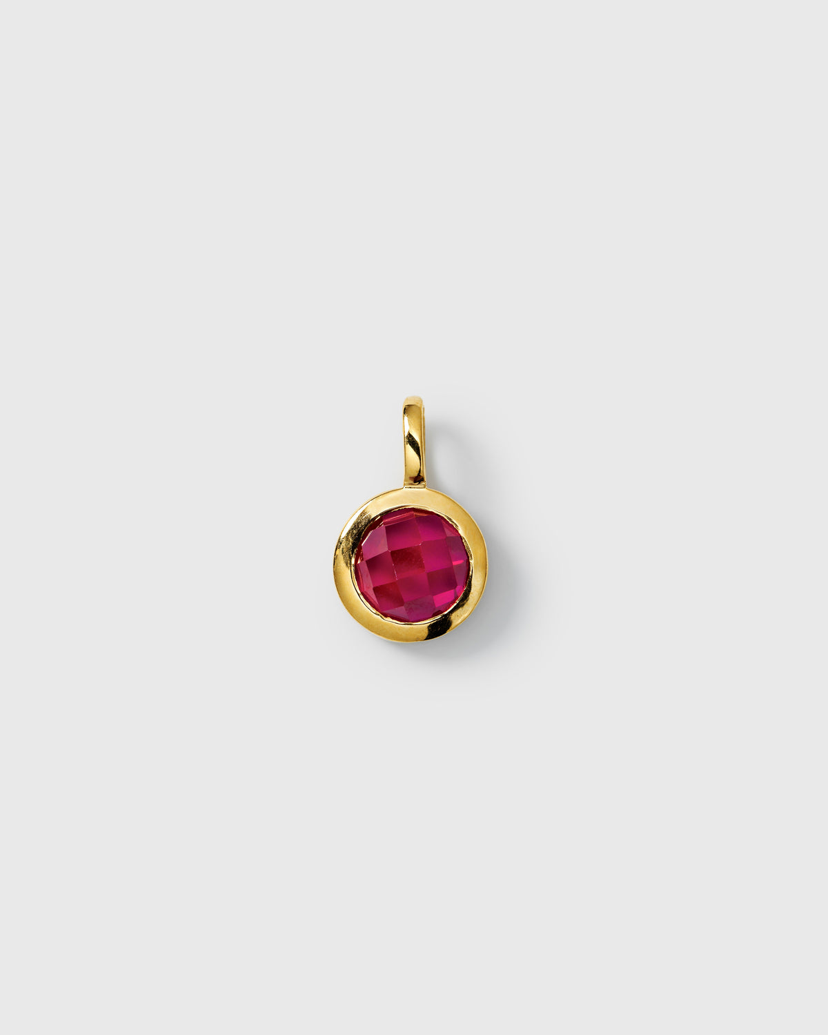 Gold pendant featuring a round faceted ruby, July birthstone.