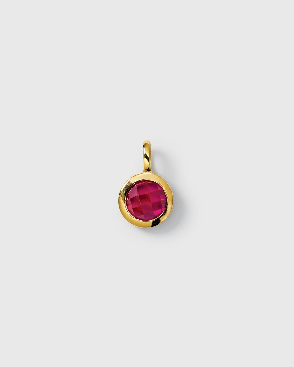 Gold pendant featuring a round faceted ruby, July birthstone.