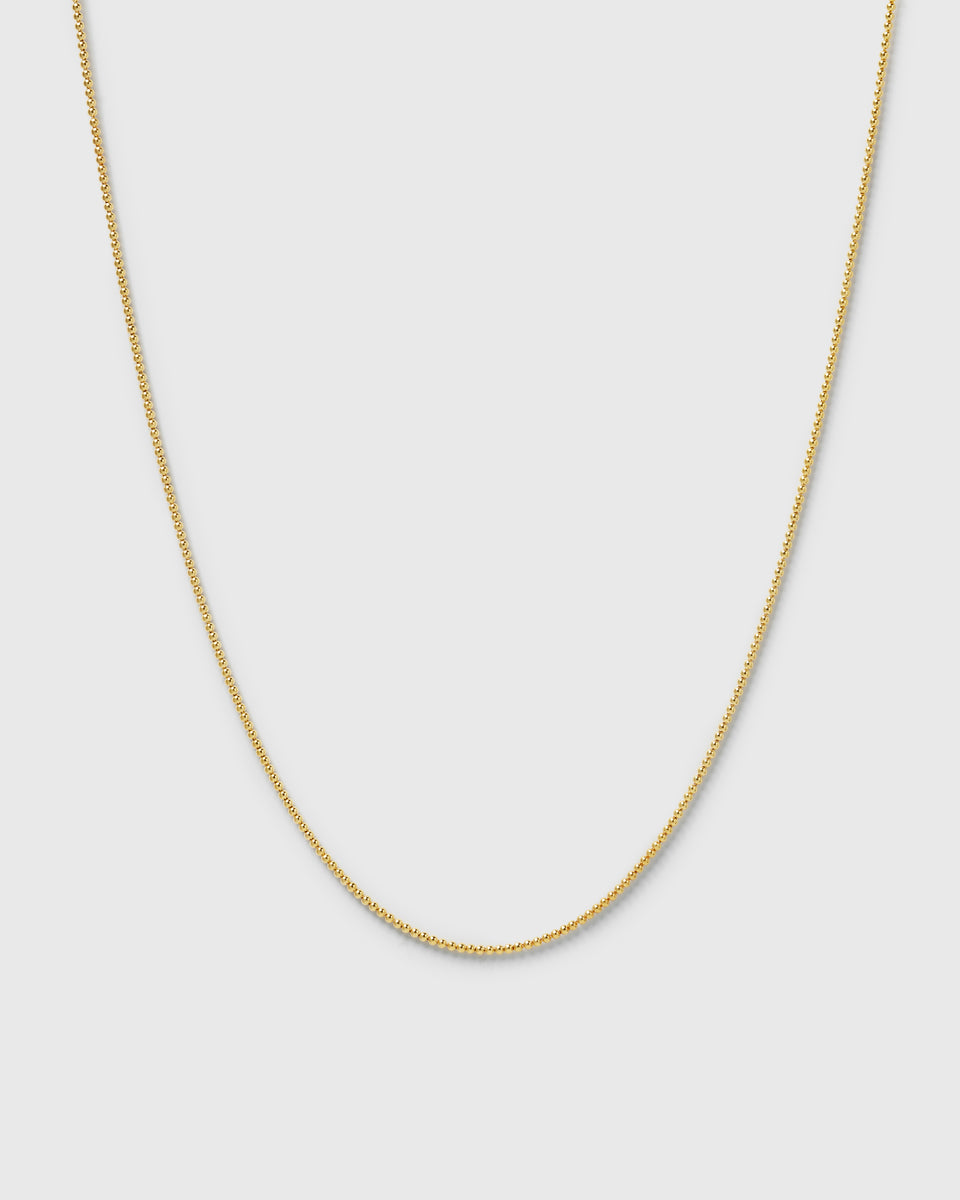 A product shot of the Sheer Doria Necklace in gold, a delicate necklace with a fine ball chain design.
