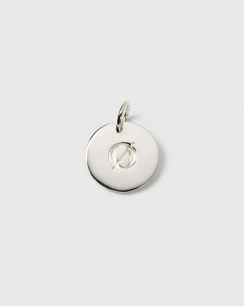 A product shot of the Beloved Big Letter Silver charm, a round disc engraved with the letter Ø.