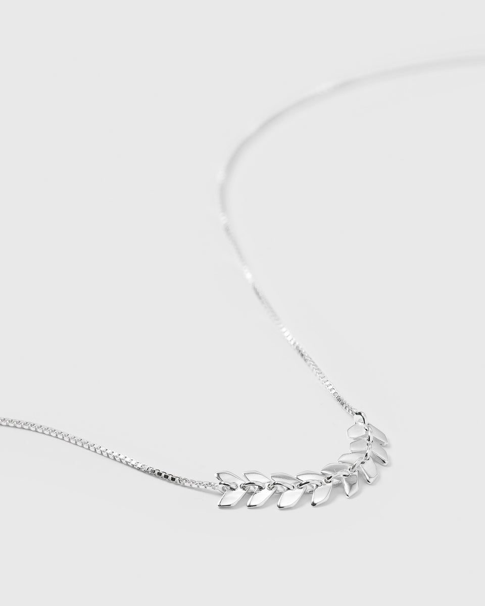 A close-up product shot of the Layers Simone Necklace in silver, highlighting the fine chain and the intricate pattern created by its small, leaf-like links.