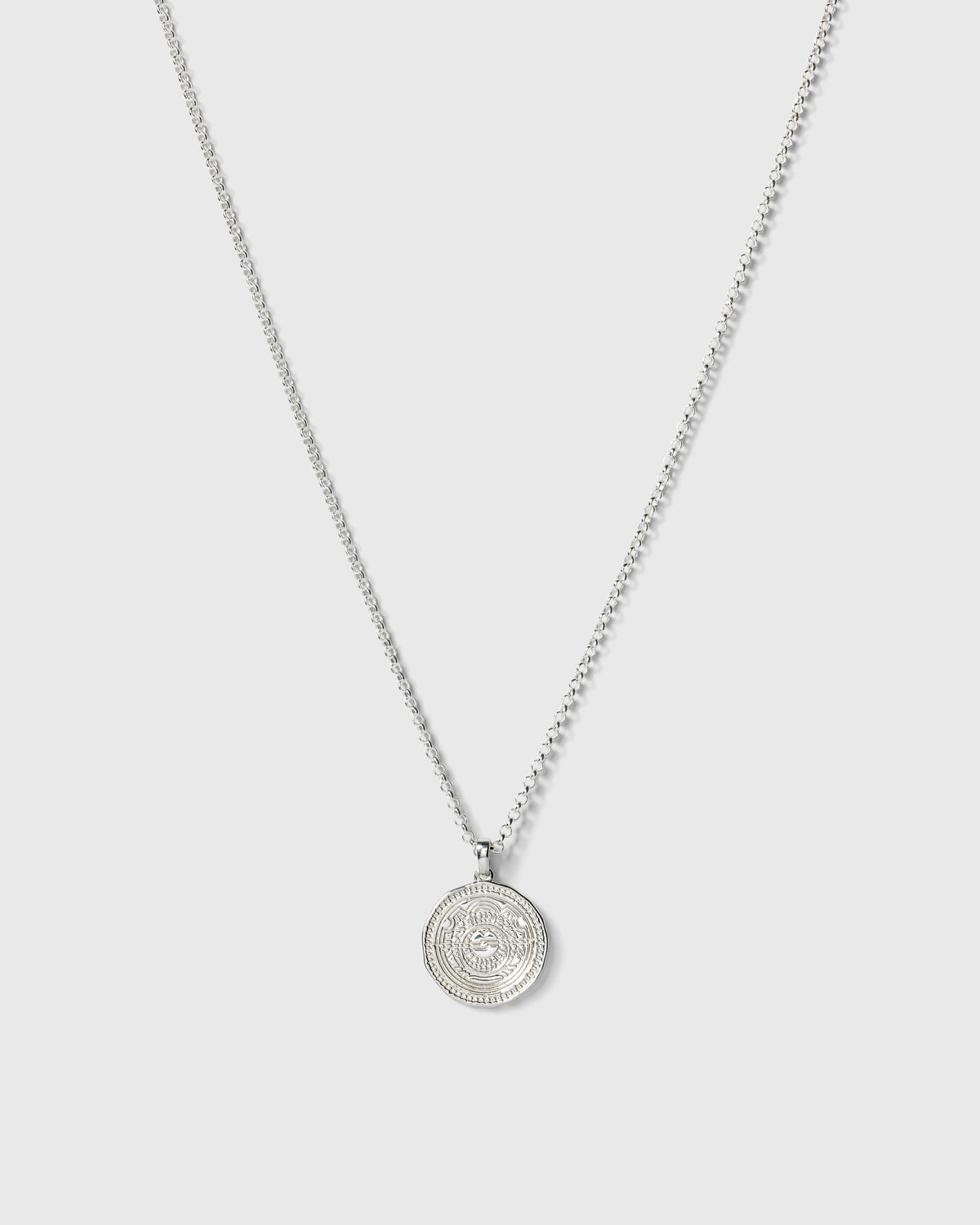 A product shot of the Lucky Coin Navigate Necklace in silver, featuring a thin ball chain and a round, coin-like pendant with a compass design.