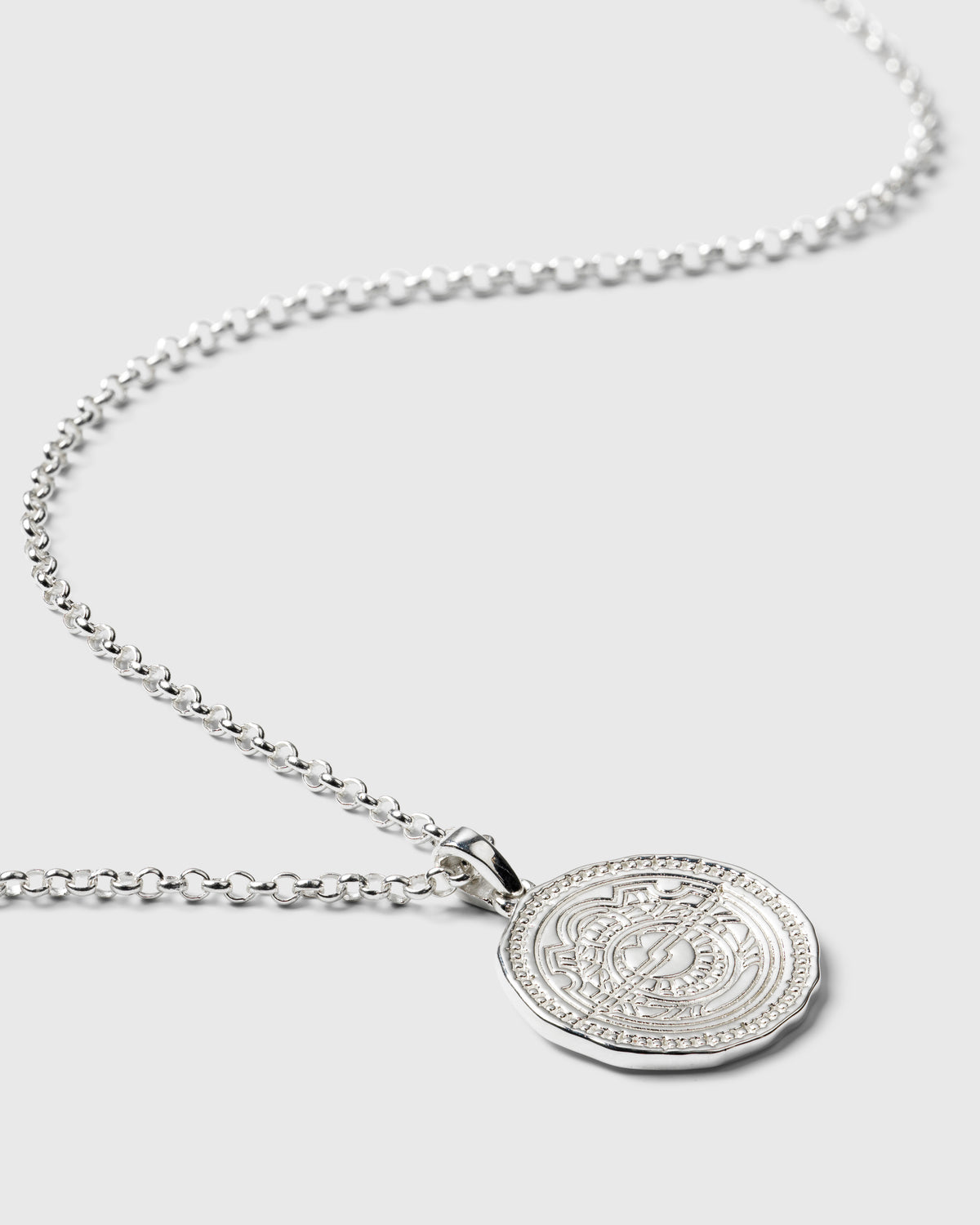 A product shot of the Lucky Coin Navigate Necklace in silver, showing the intricate compass design on the coin pendant and its fine link chain.