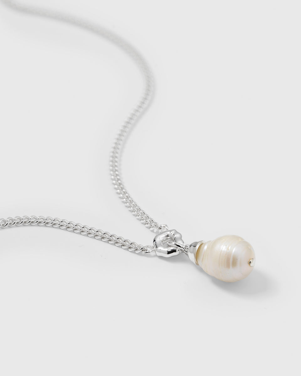 A close-up product shot of the Mary Necklace Silver, focusing on its heavy sterling silver chain and unique baroque pearl pendant.
