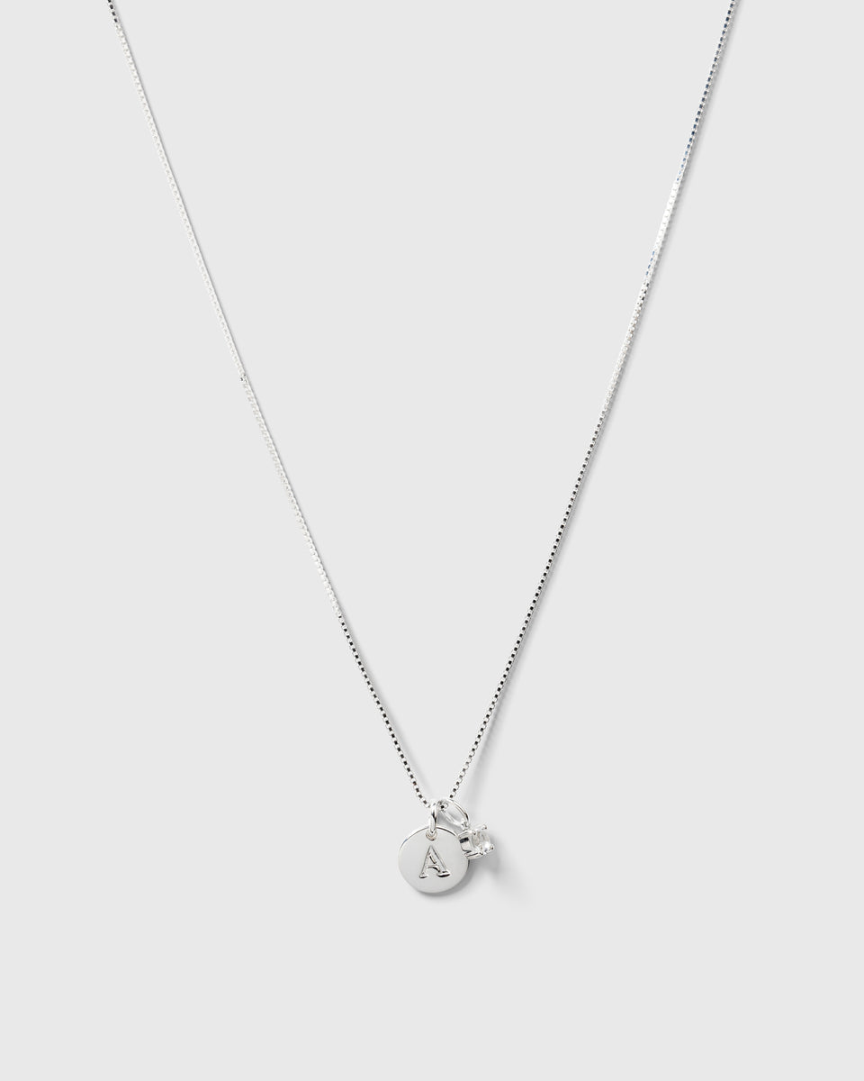 A product shot of the Beloved Solo Nova Pendant in silver, styled on a box chain with a round initial 'A' pendant.