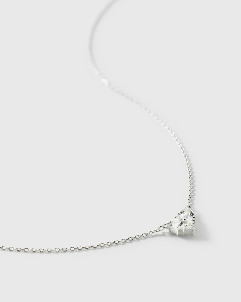 A close-up product shot of the Pam Necklace in silver, showcasing the intricate pendant composed of various shaped white topaz stones attached to a delicate chain.
