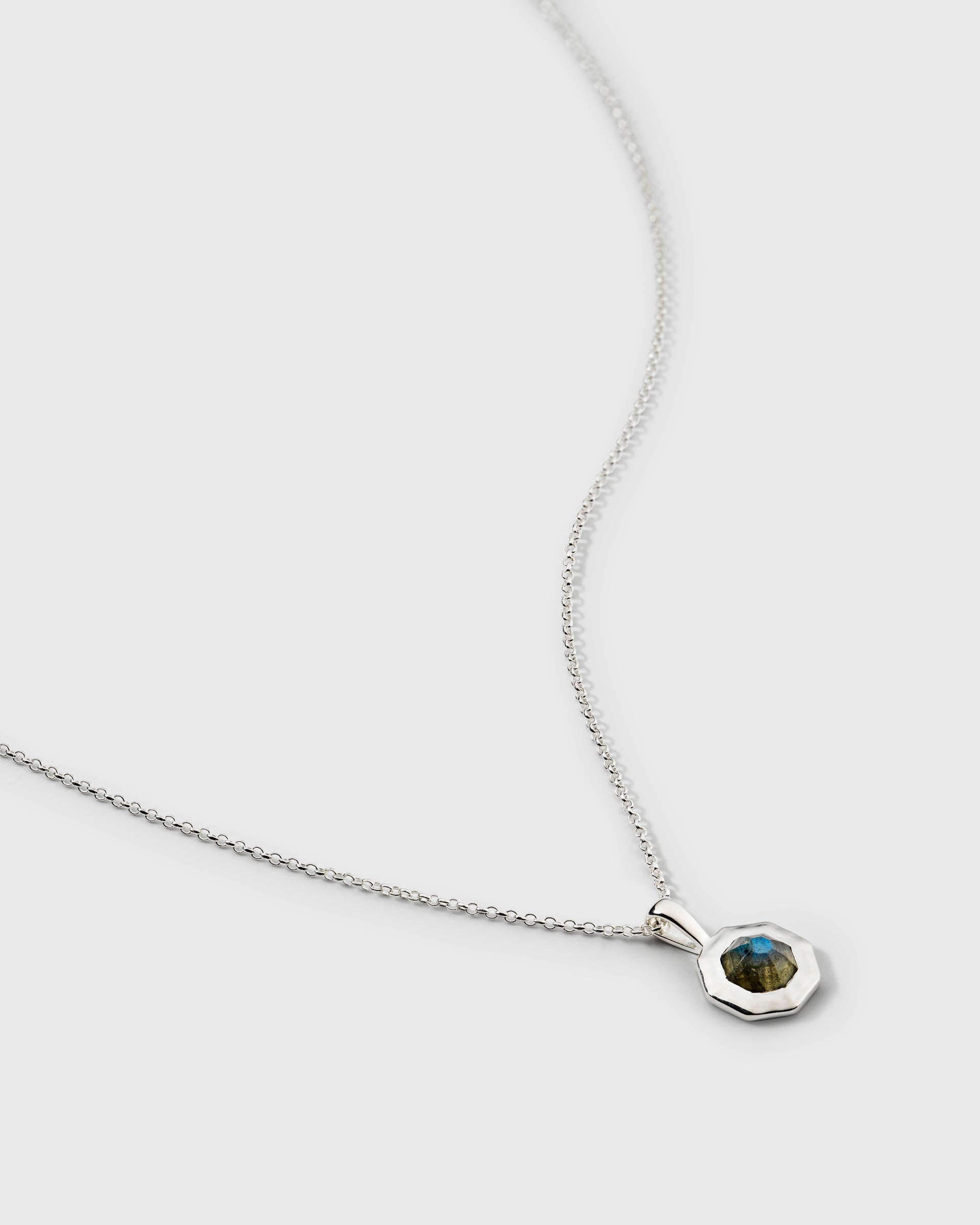 A necklace in silver, featuring an octagonal pendant with a central labradorite stone on a delicate chain.