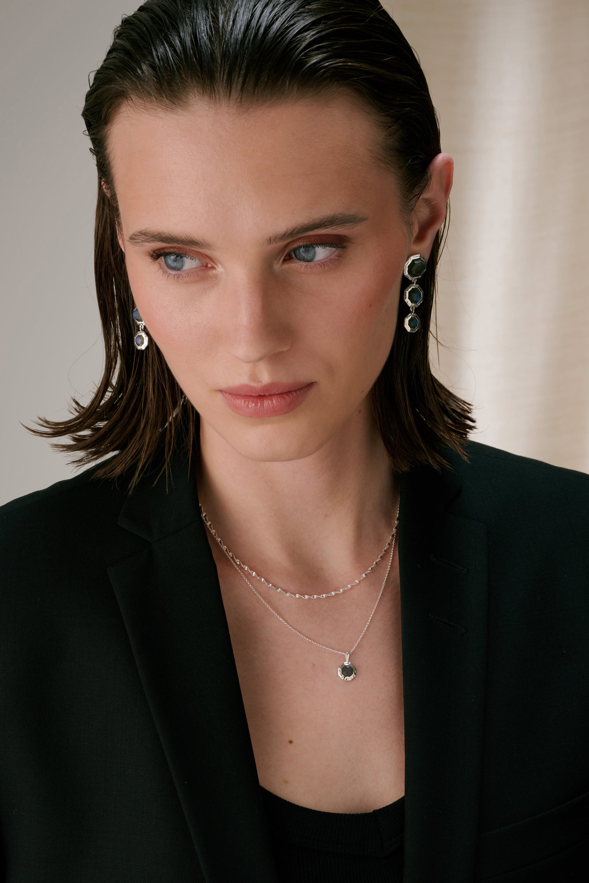 Two necklaces – one is a twisted chain, and the other features an octagon-shaped pendant set with a faceted labradorite in a hammered setting.