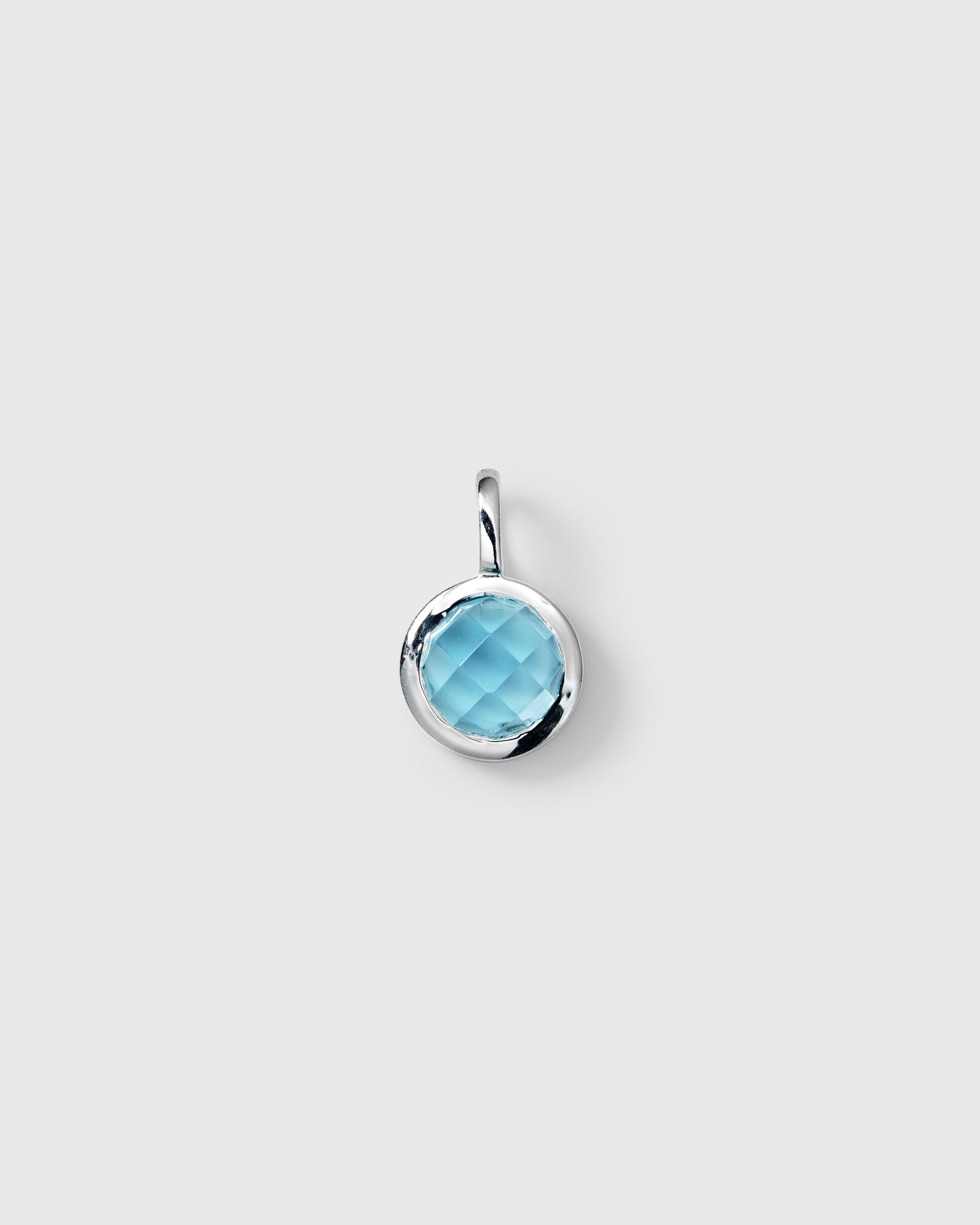 Silver pendant featuring a round faceted light blue topaz, September birthstone.