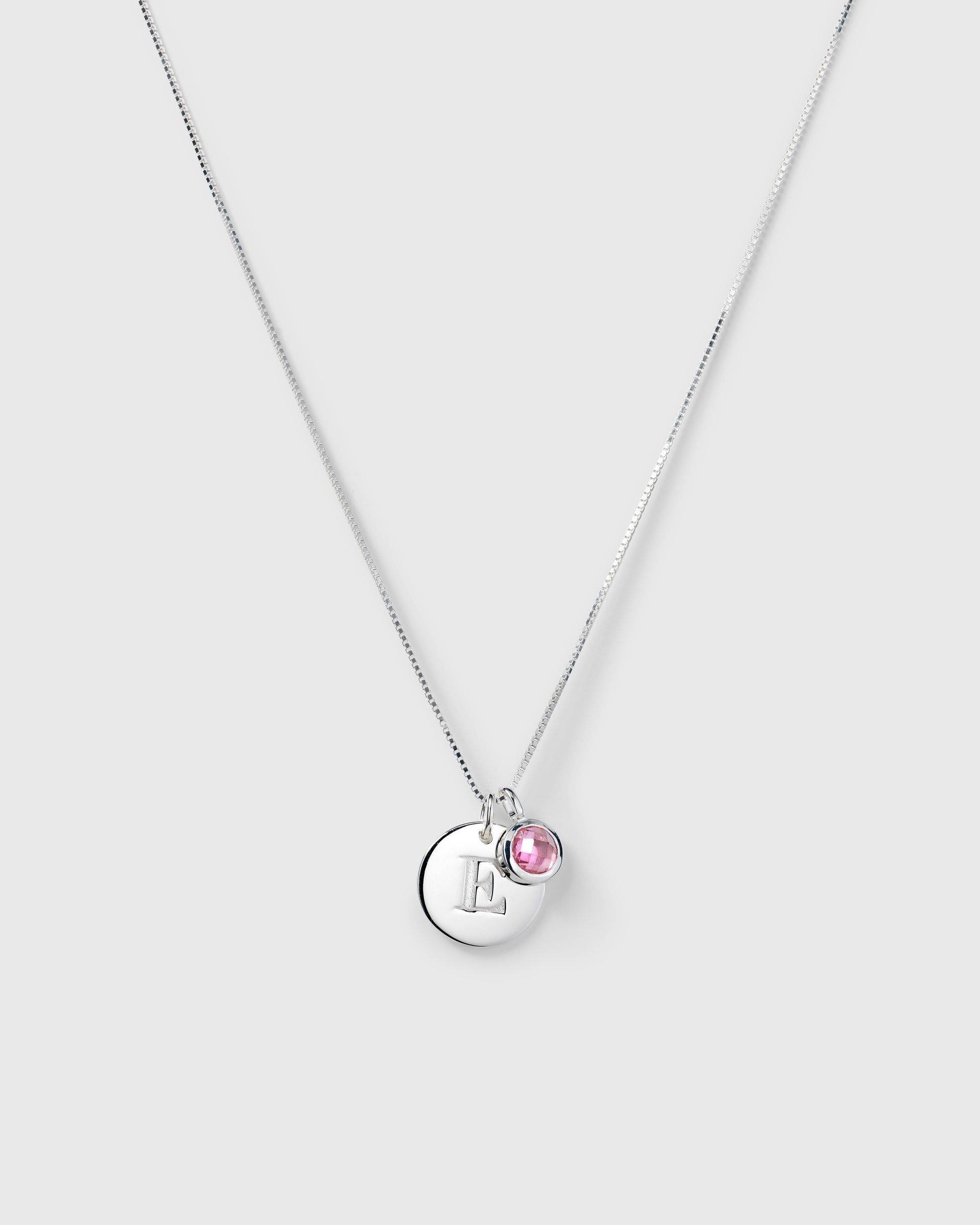 Silver necklace with two pendants: an October birthstone pink tourmaline and a round lettercharm.