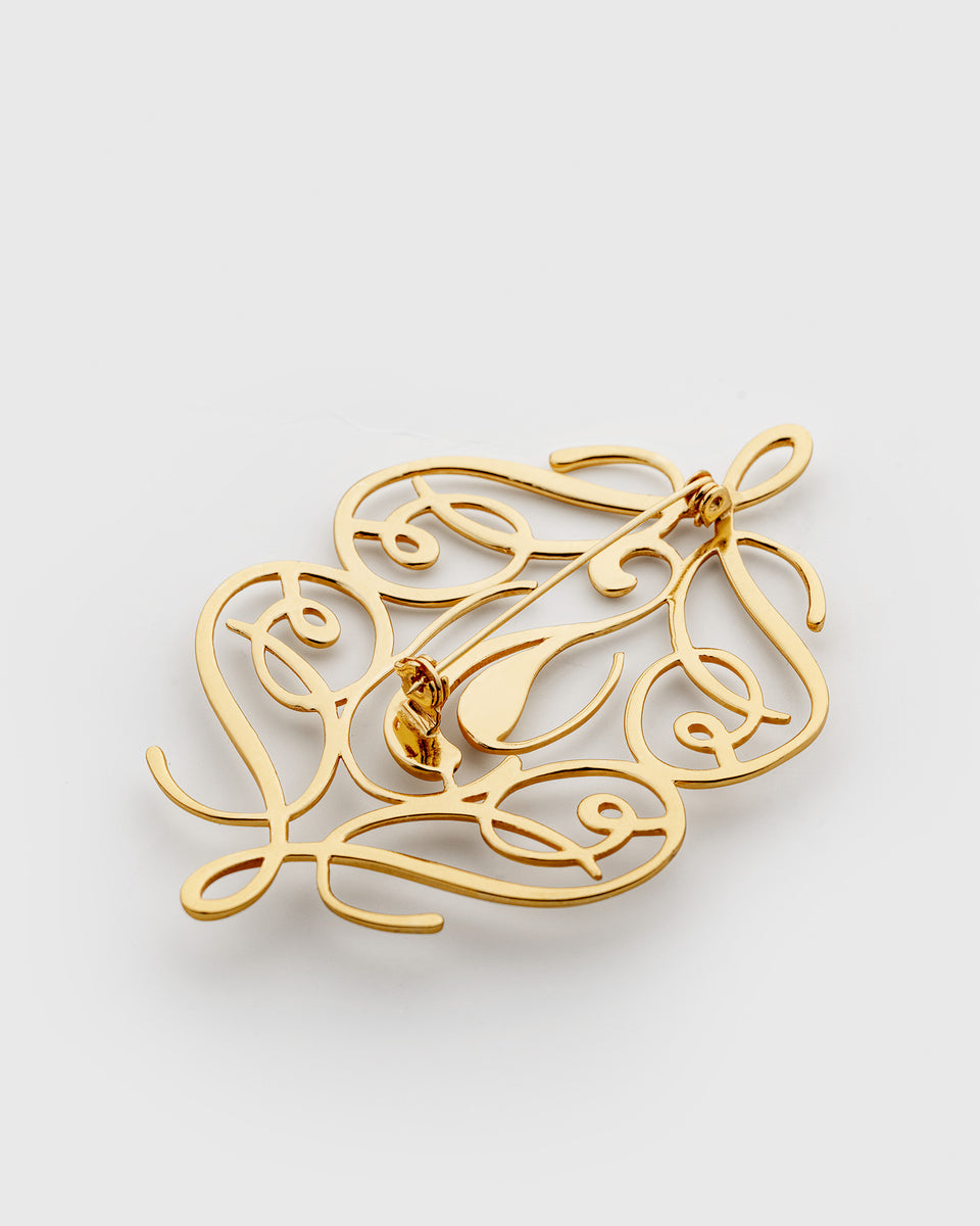 A product shot of the Ophelia Brooch in gold, viewed from the back to display its pin fastening and the intricate, swirling design.