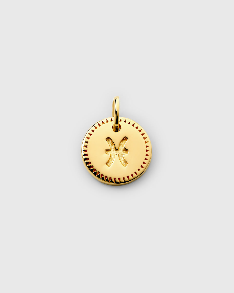 A product shot of the Beloved Zodie Pendant in gold, showcasing the Pisces variant. The round charm features the engraved Pisces symbol at its center, framed by a decorative border.