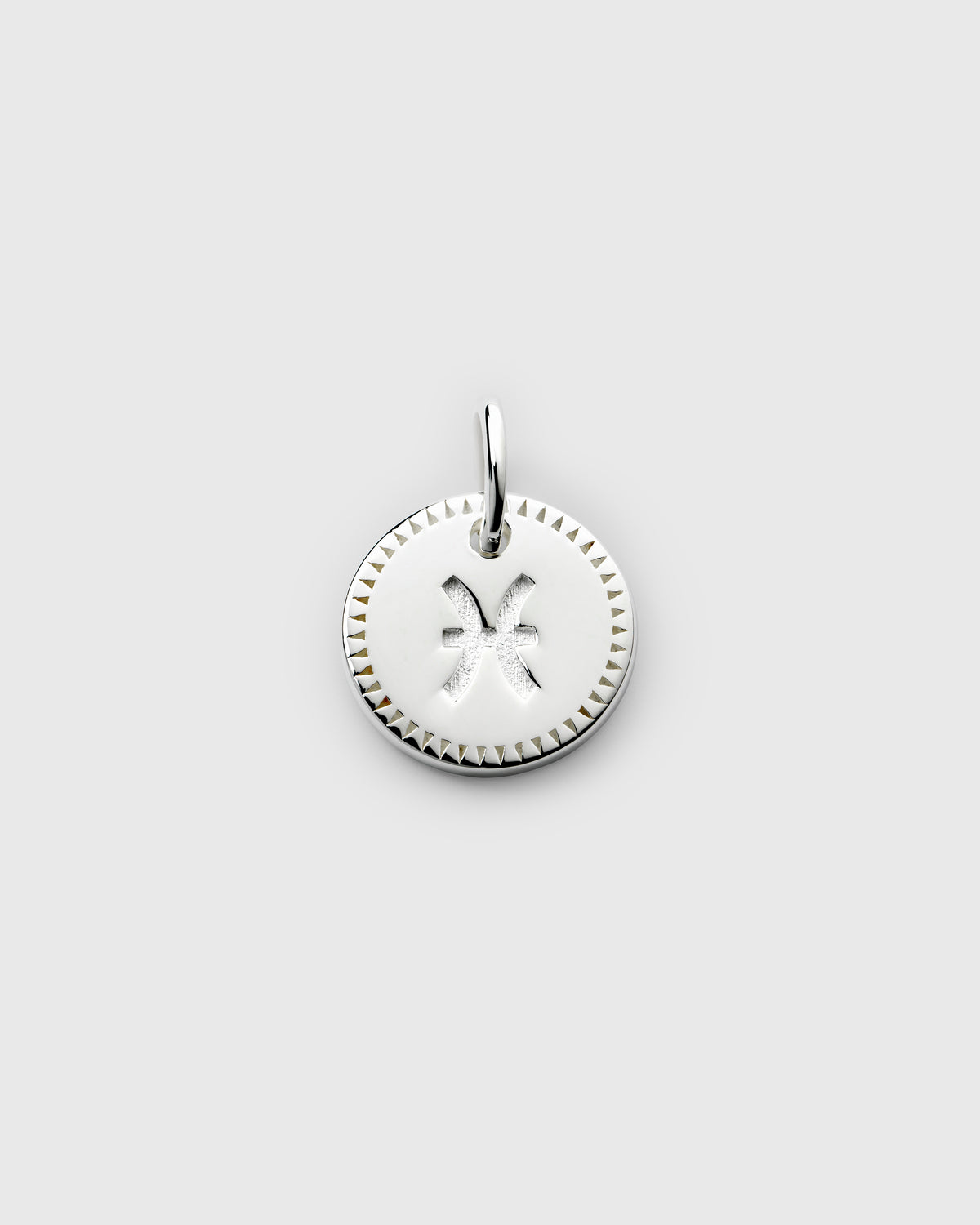 A product shot of the Beloved Zodie Pendant in silver, featuring the Pisces zodiac sign engraved on the circular charm, which is framed by a decorative triangular border.