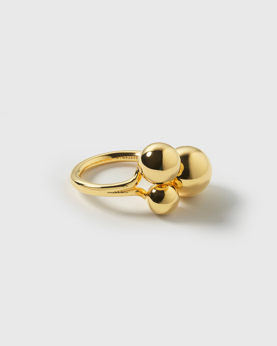A product shot of the Universe Ring in gold, featuring three polished spheres in different sizes clustered on top of the band.