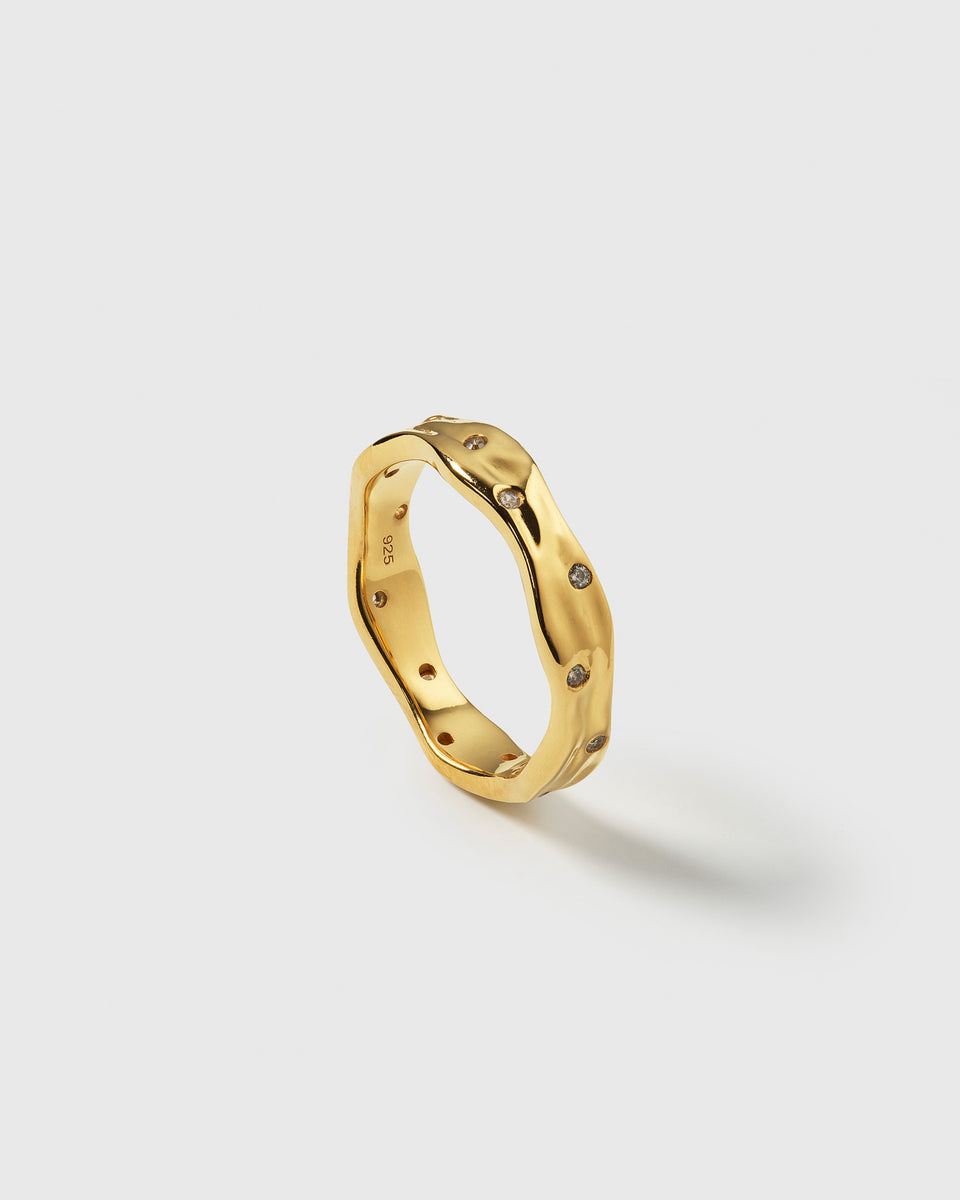 A product shot of the Melting Narrow Ring in gold, showcasing its unique wavy and melted design, studded with sparkling white zirconias.