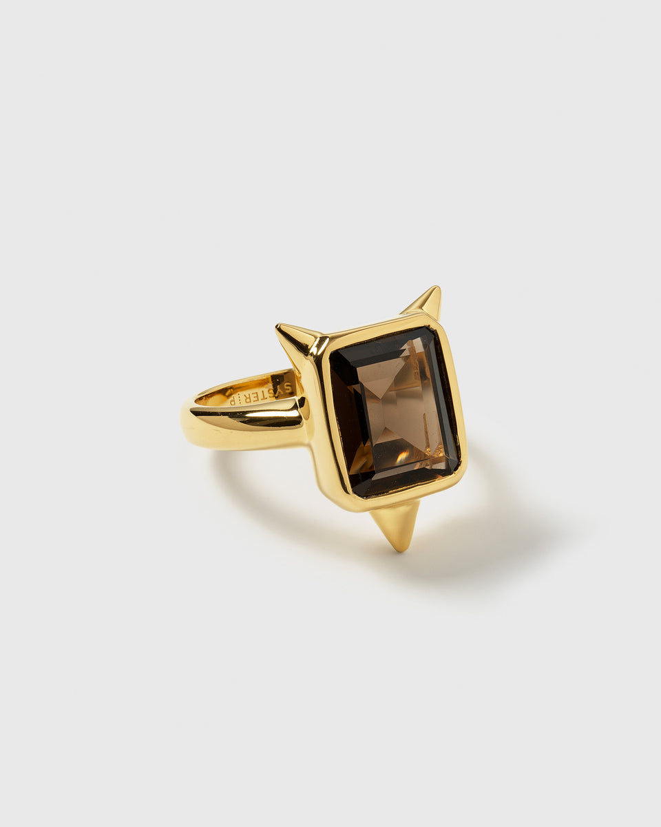 A product shot of the Drama Ring in gold, showcasing its large square smokey quartz gemstone and three edgy spikes.