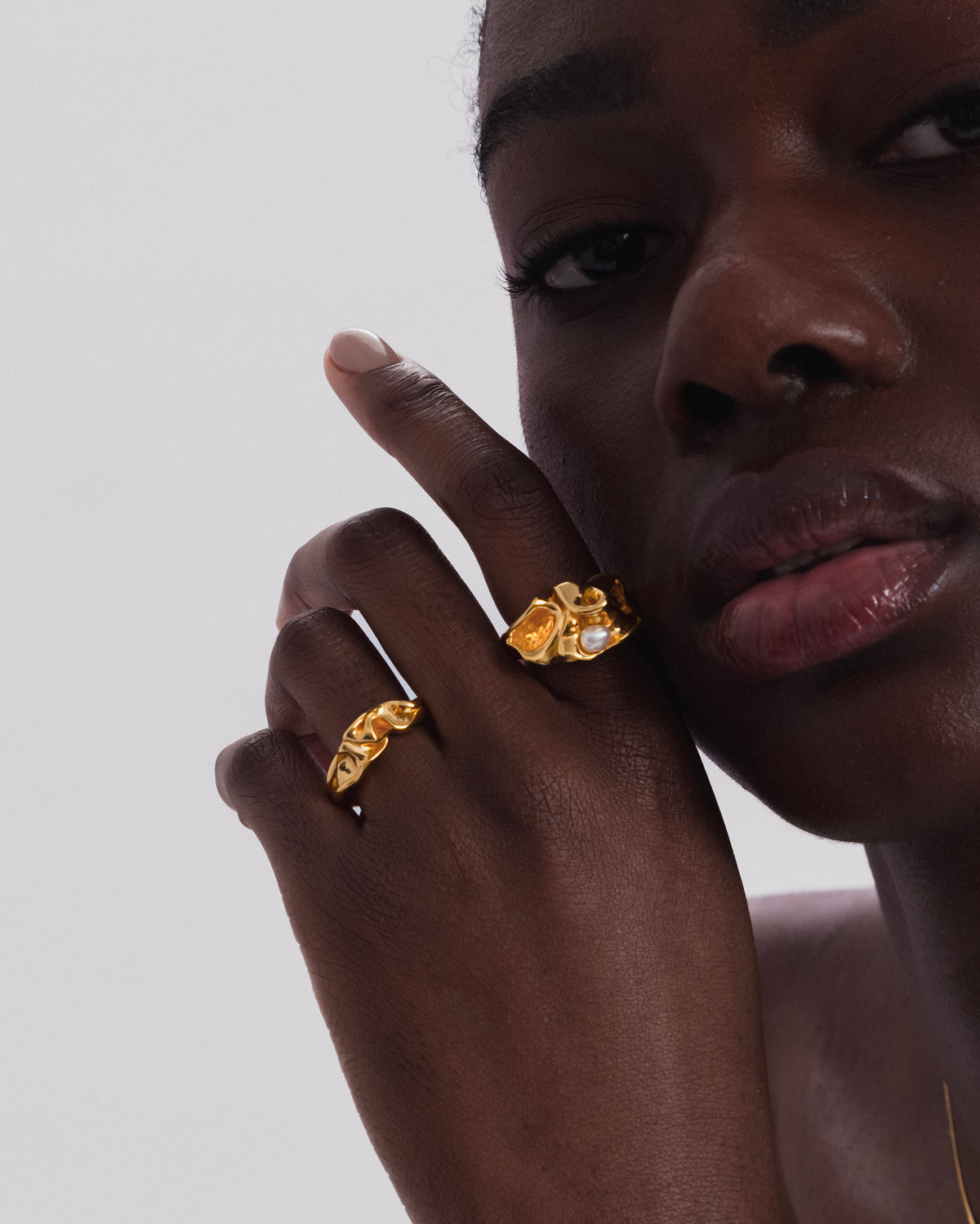 A model wears the organically shaped Moulded Big Ring in gold with a freshwater pearl, styled with the matching Moulded Narrow Ring.