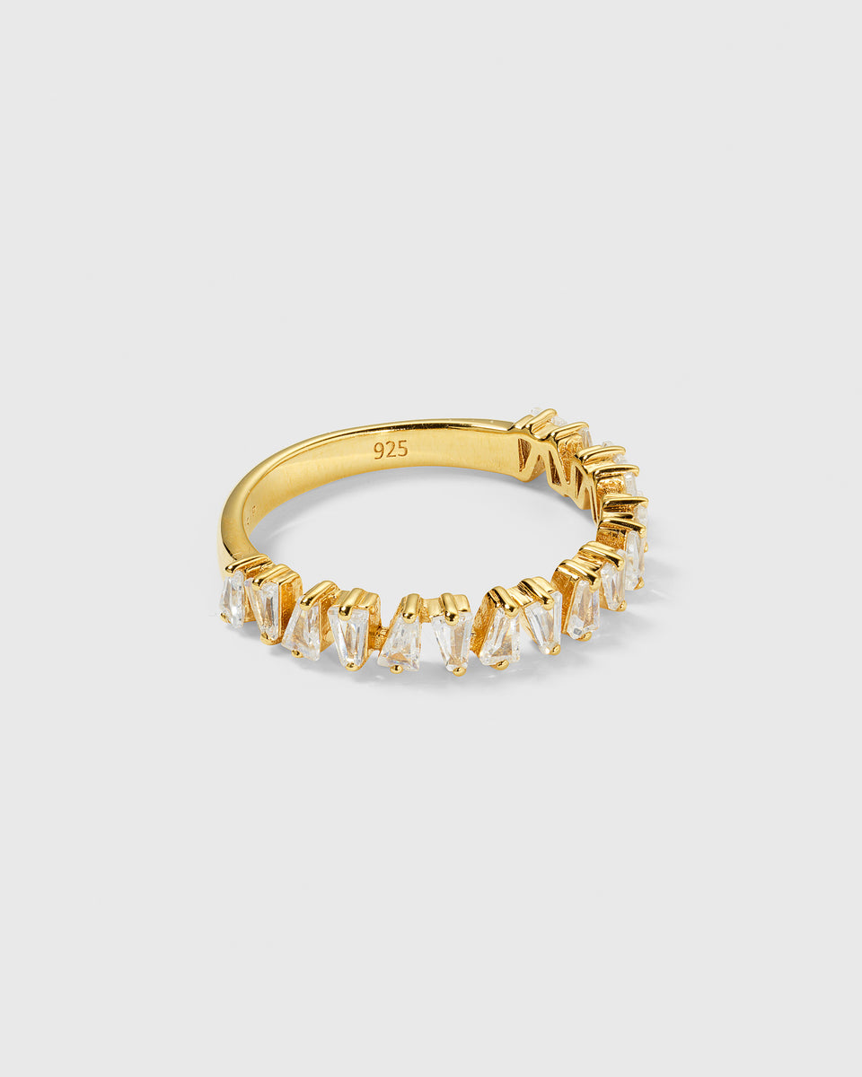 A product shot of the Iggy Ring in gold, showcasing its design of tapered baguette-cut cubic zirconias set around the top half of the band.