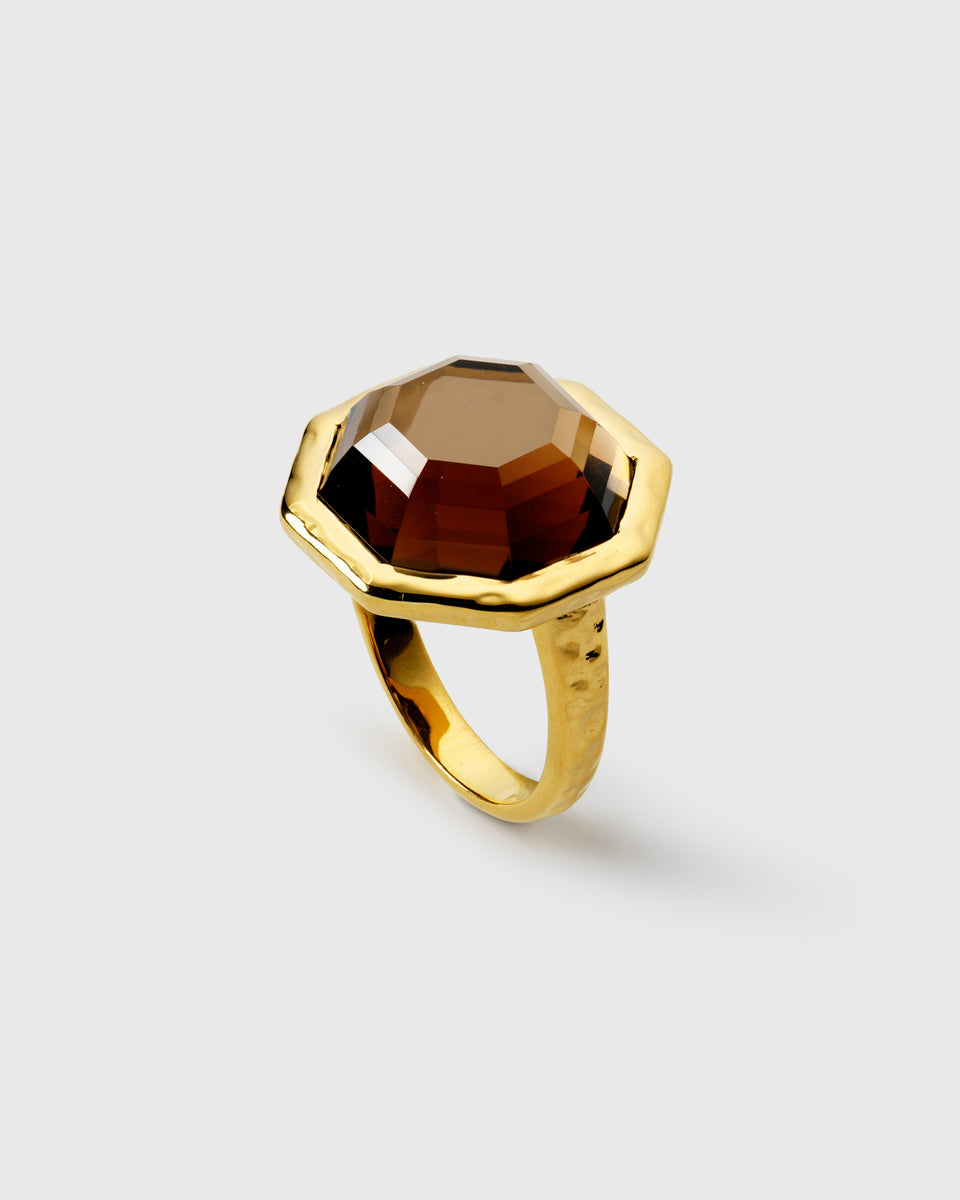 Ring in gold, featuring a large, faceted, octagonal smokey quartz stone set on a hammered-finish band.