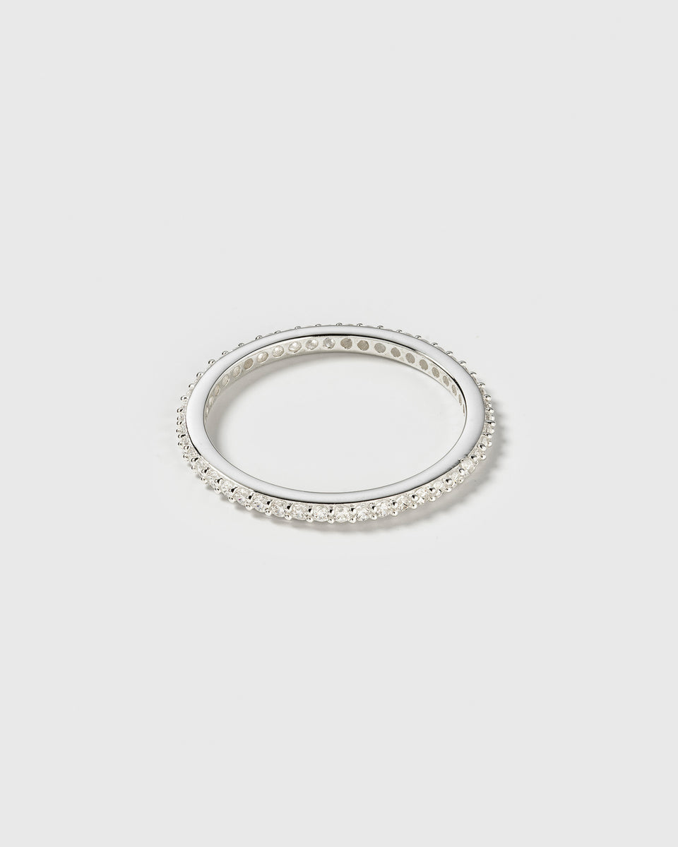 A product shot of the Tiny Sparkle Ring in silver, an eternity band fully set with small, sparkling white zirconias.
