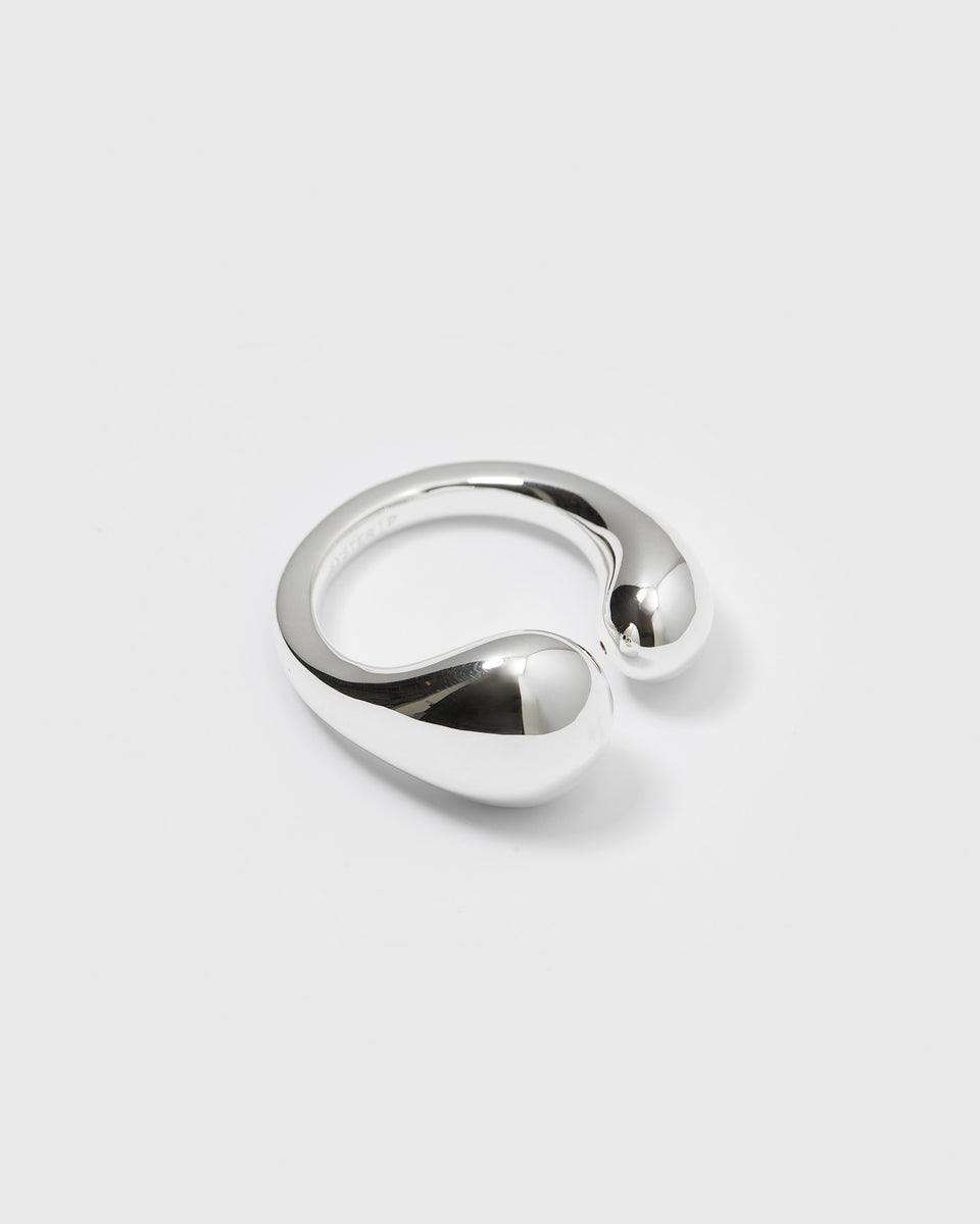 A product shot of the Bolded Drops Ring in silver, showcasing its open design with two bold, polished, drop-shaped ends.