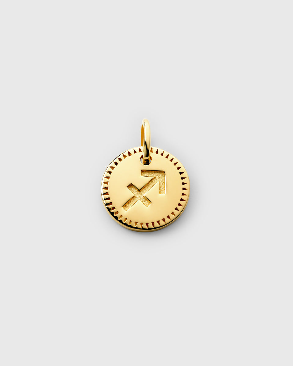 A product shot of the gold Beloved Zodie Pendant, featuring the round Sagittarius charm with its engraved symbol and decorative border.